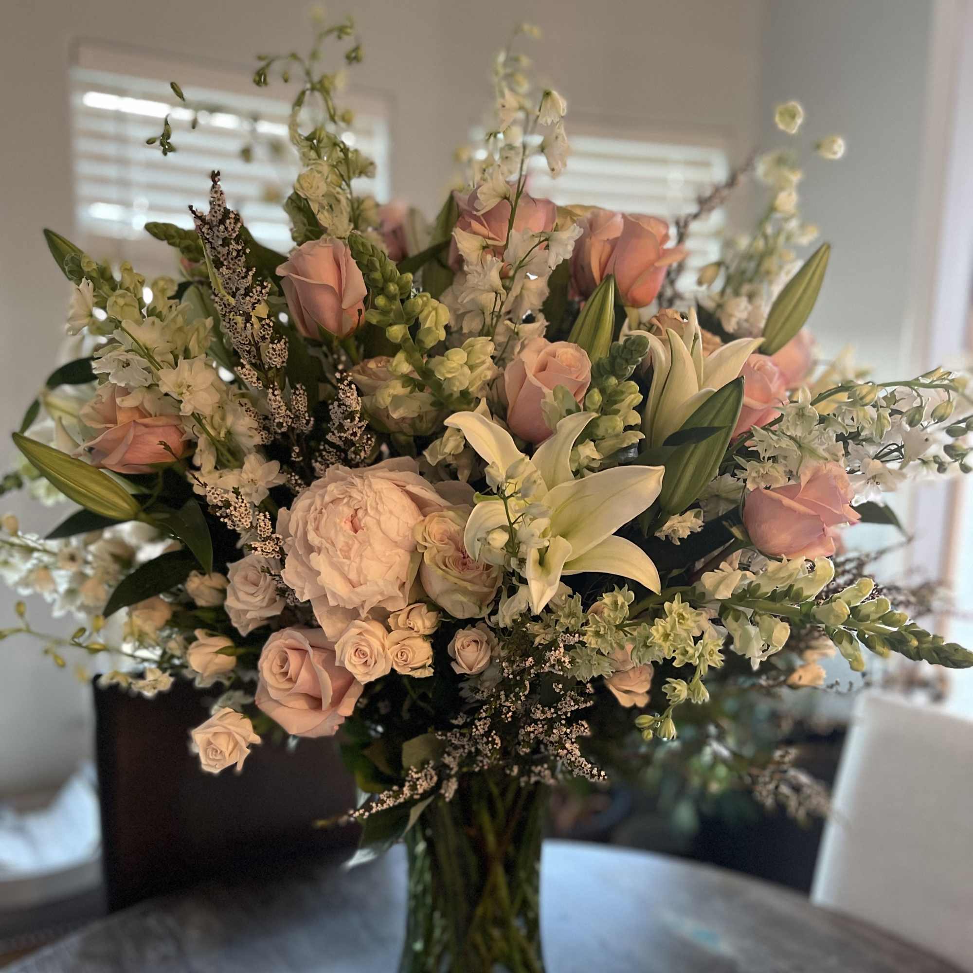 Bouquet of pale pink roses and white lilies in a glass vase