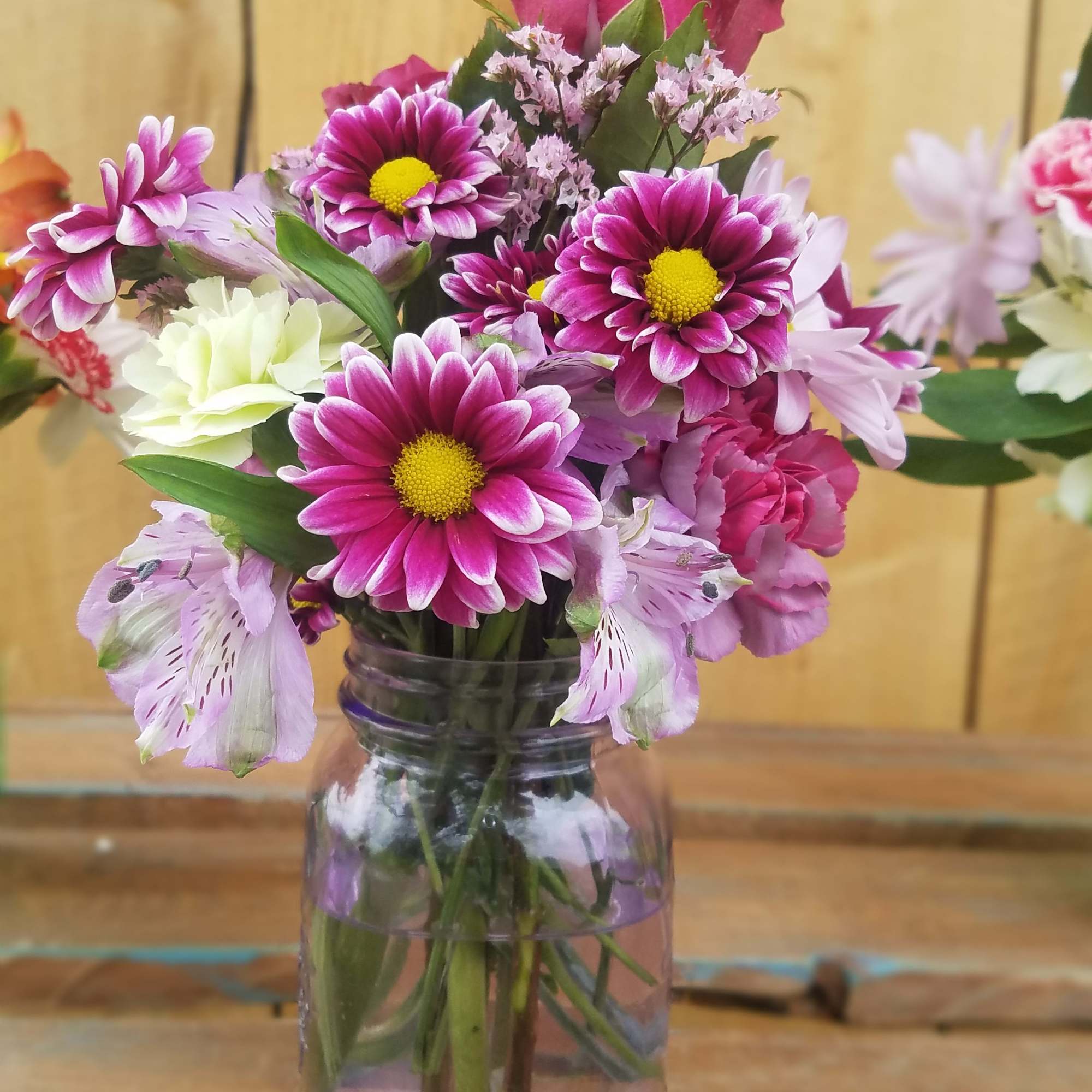 Pink and white mixed bouquet in a clear glass jar vase