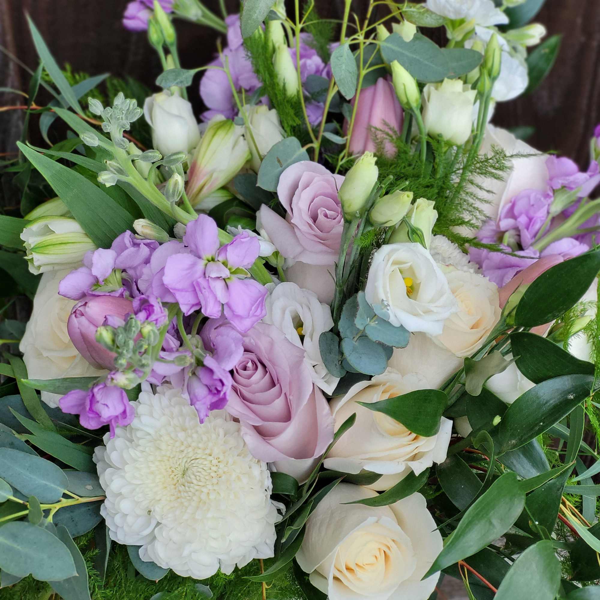 Bouquet of white and lavender roses with purple blooms