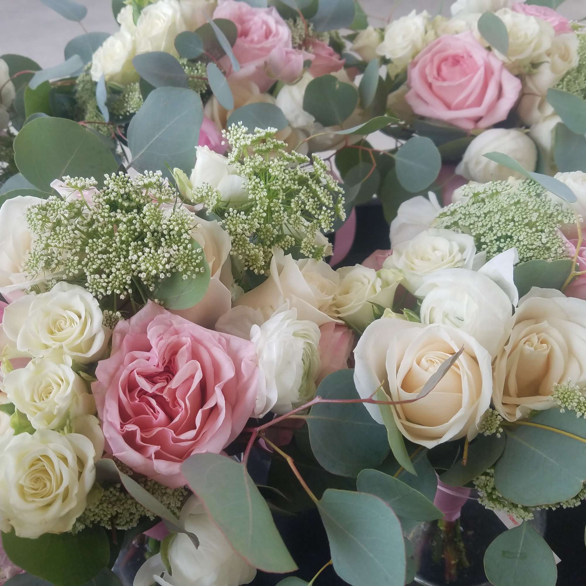 Bouquets of pink and white roses with eucalyptus