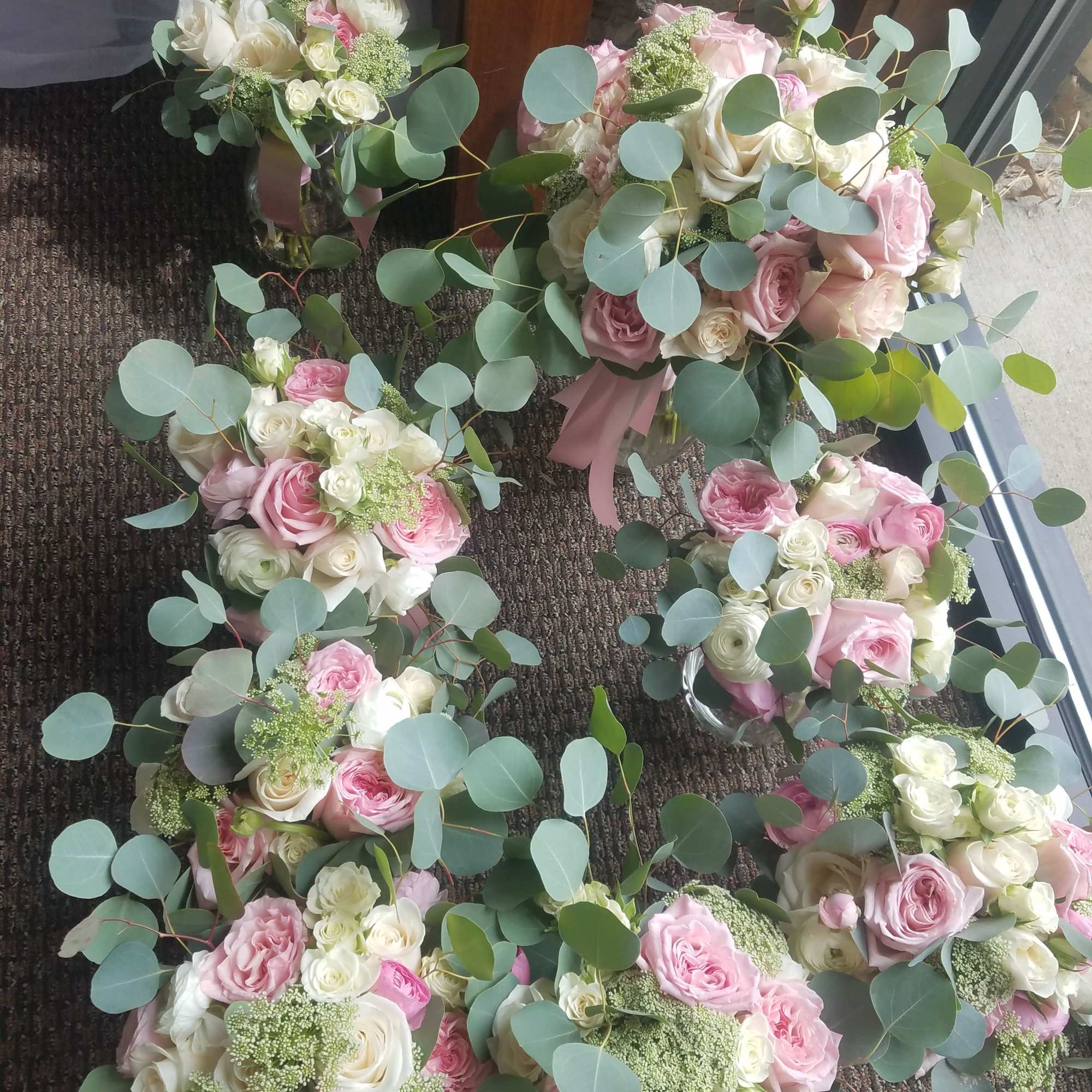 Pink and white rose bouquets with eucalyptus greenery