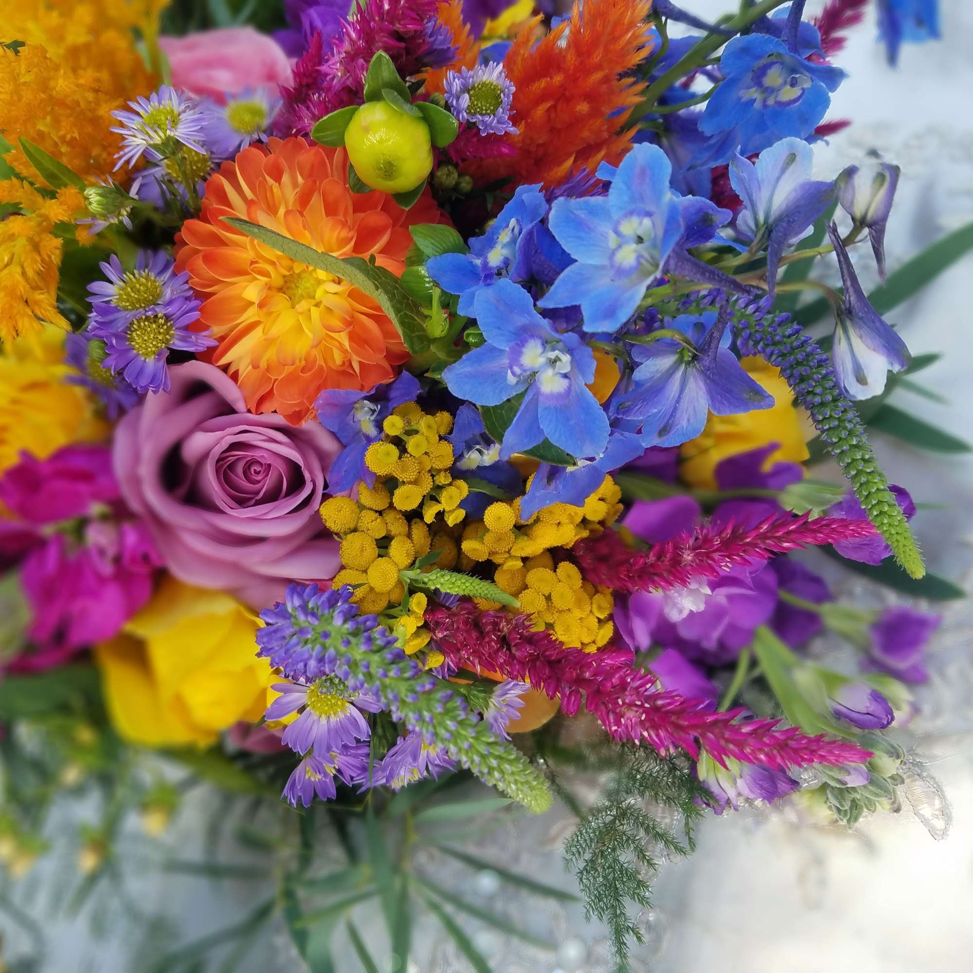 Colorful mixed bouquet with roses, dahlias, and blue flowers