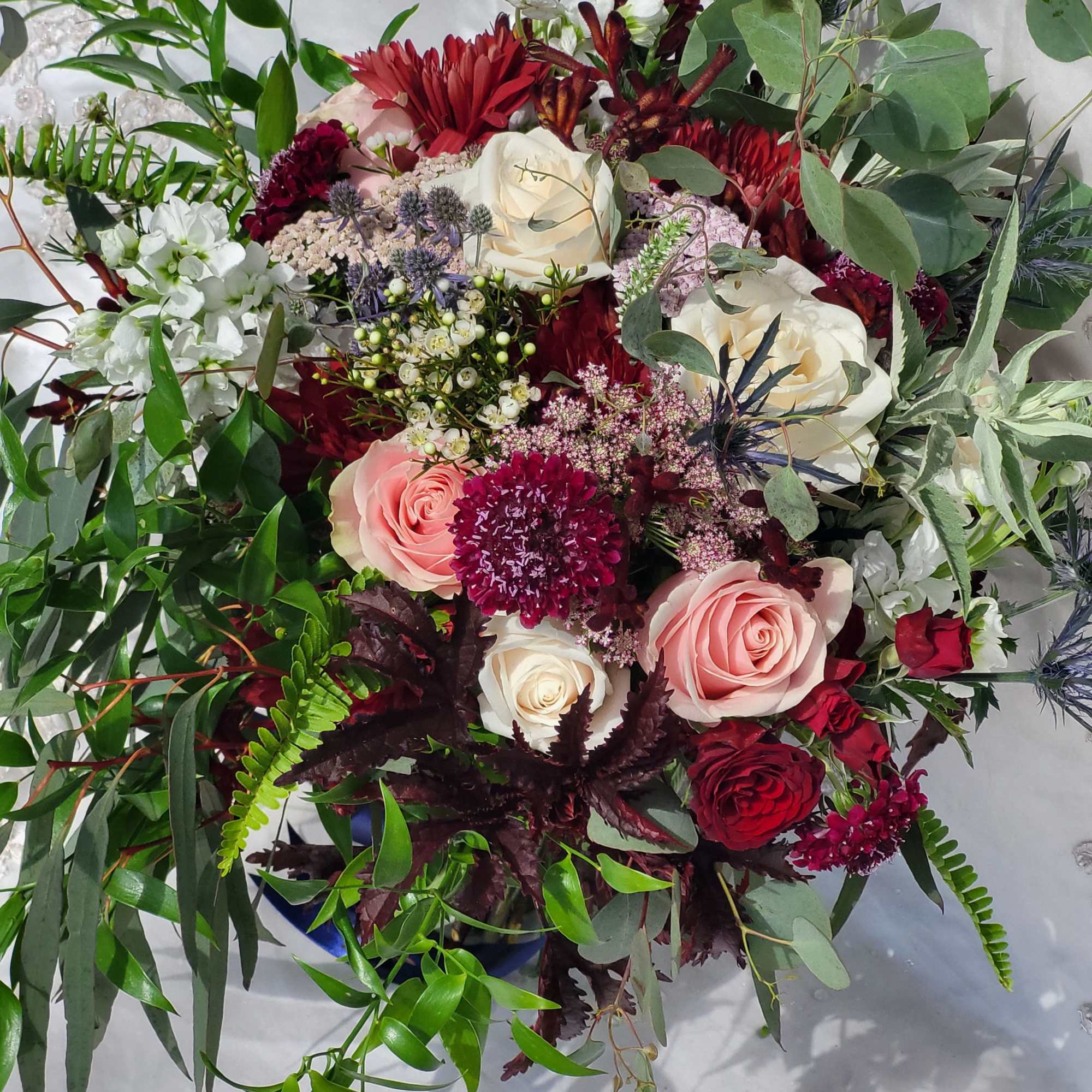 Mixed bouquet with pink and white roses and burgundy blooms