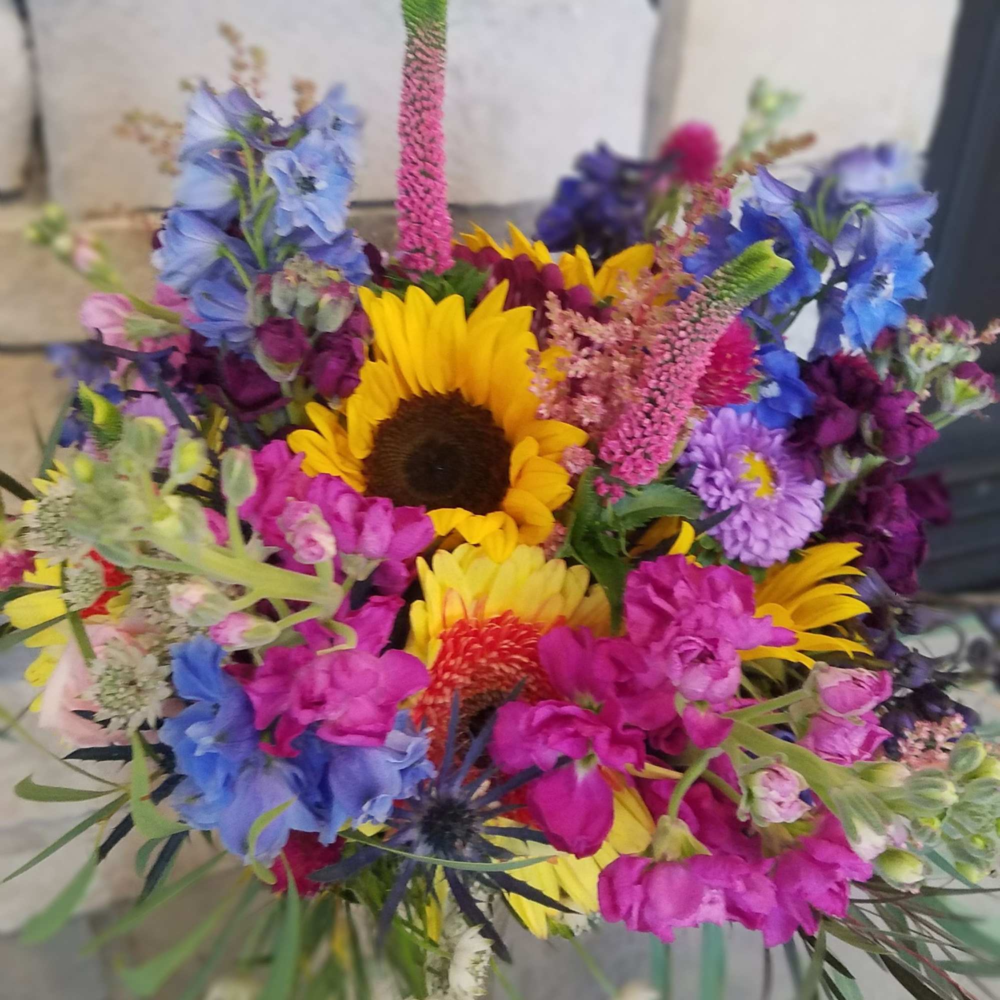 Colorful mixed bouquet with sunflowers in a glass vase