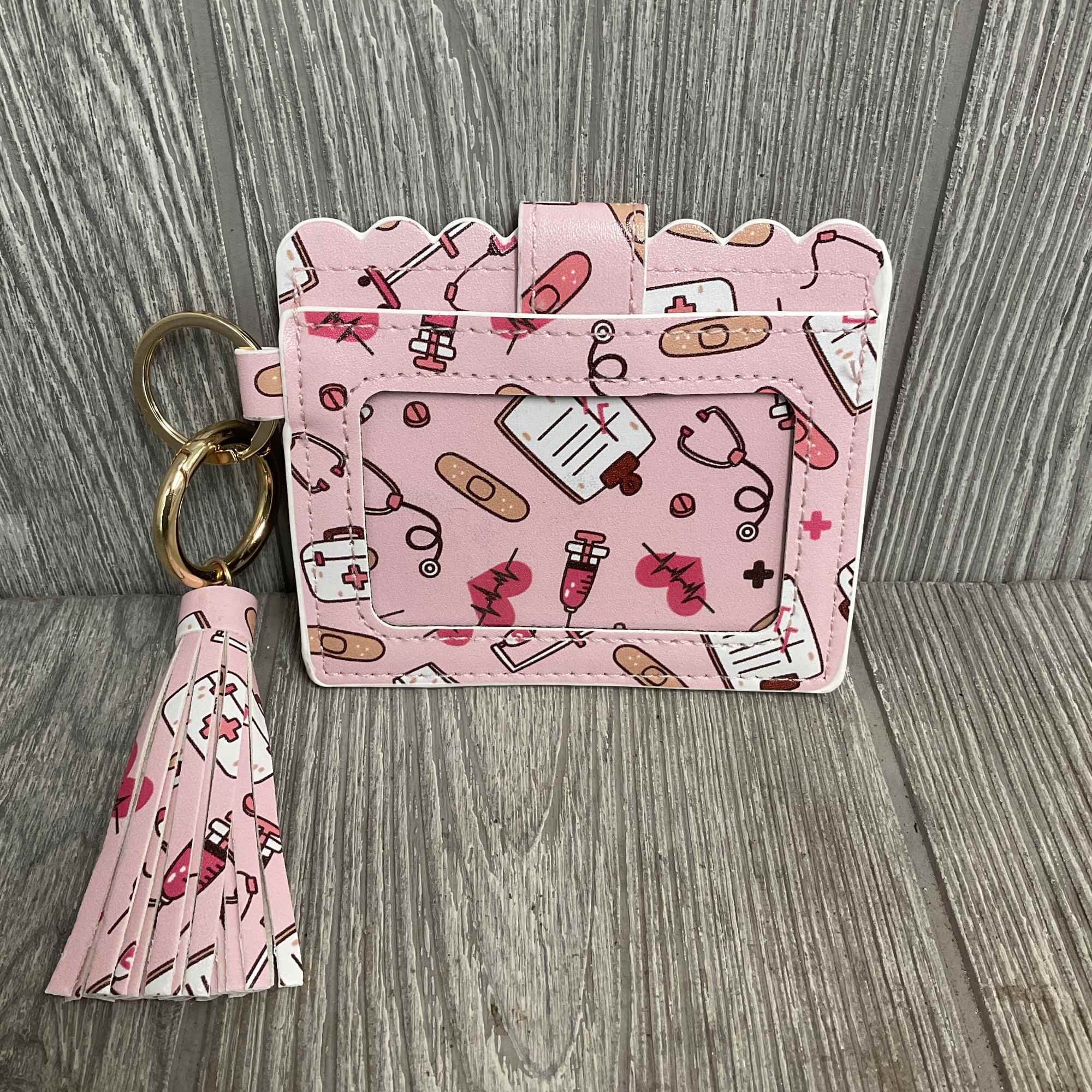 Pink medical-themed card holder with a tassel keychain