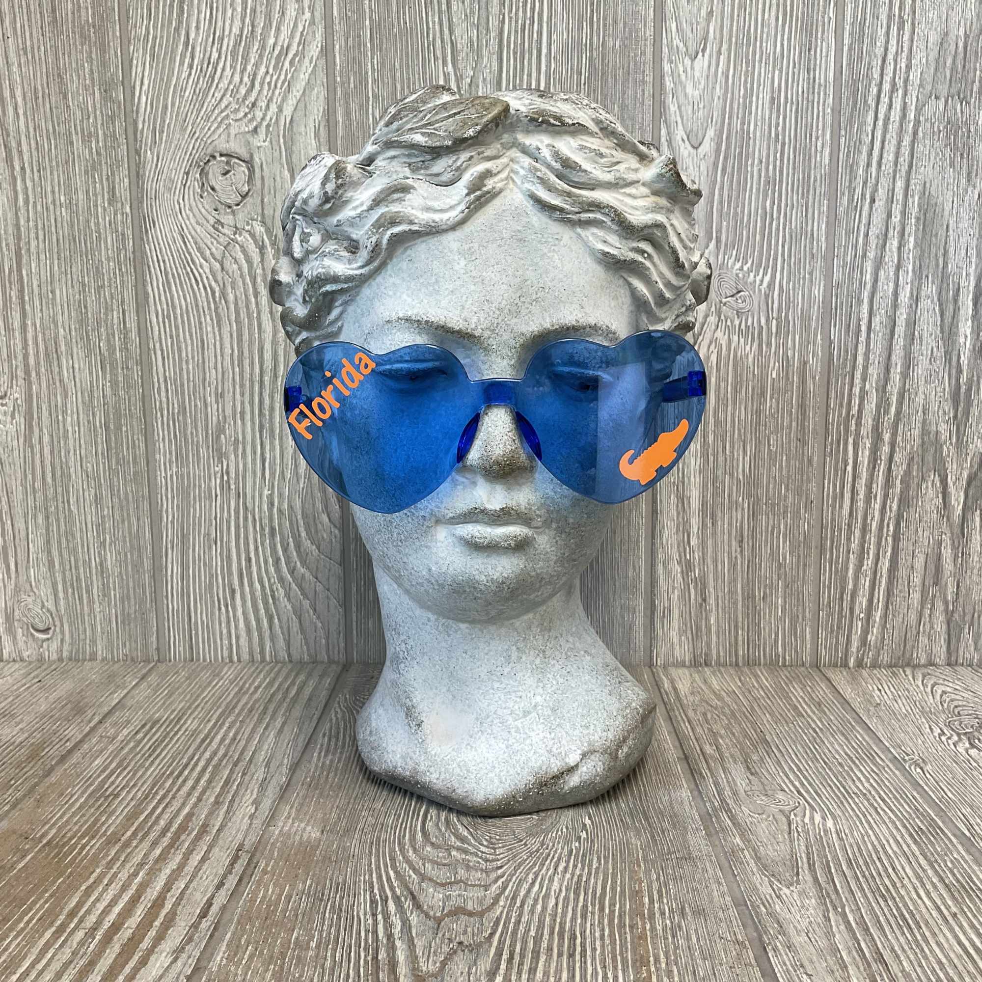 Stone bust wearing blue heart-shaped sunglasses