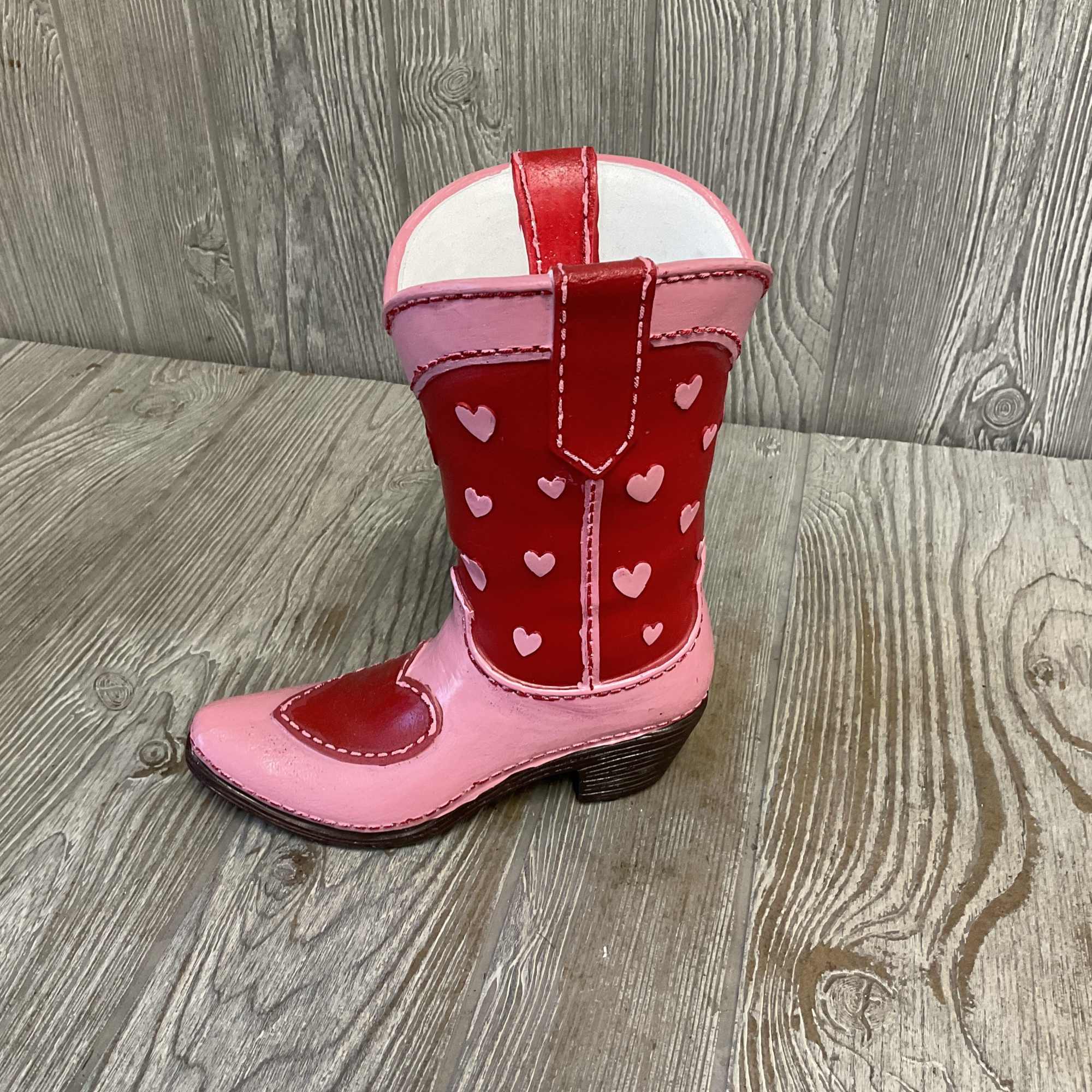 Pink and red child-sized cowboy boot with heart decorations