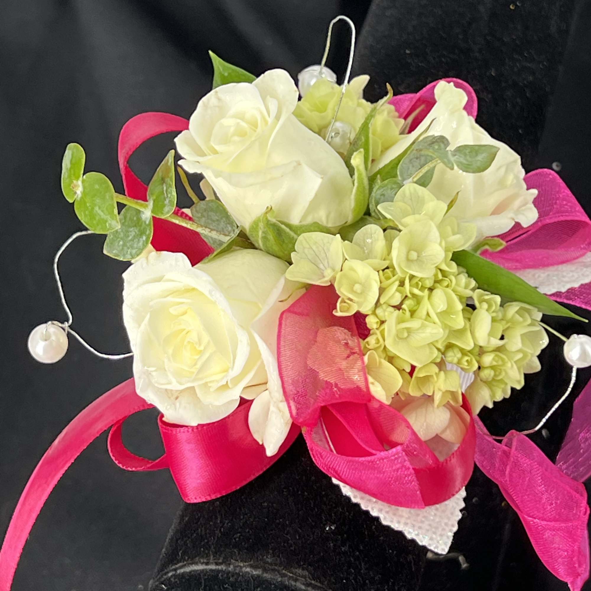 White rose corsage with pink ribbon and pearl accents
