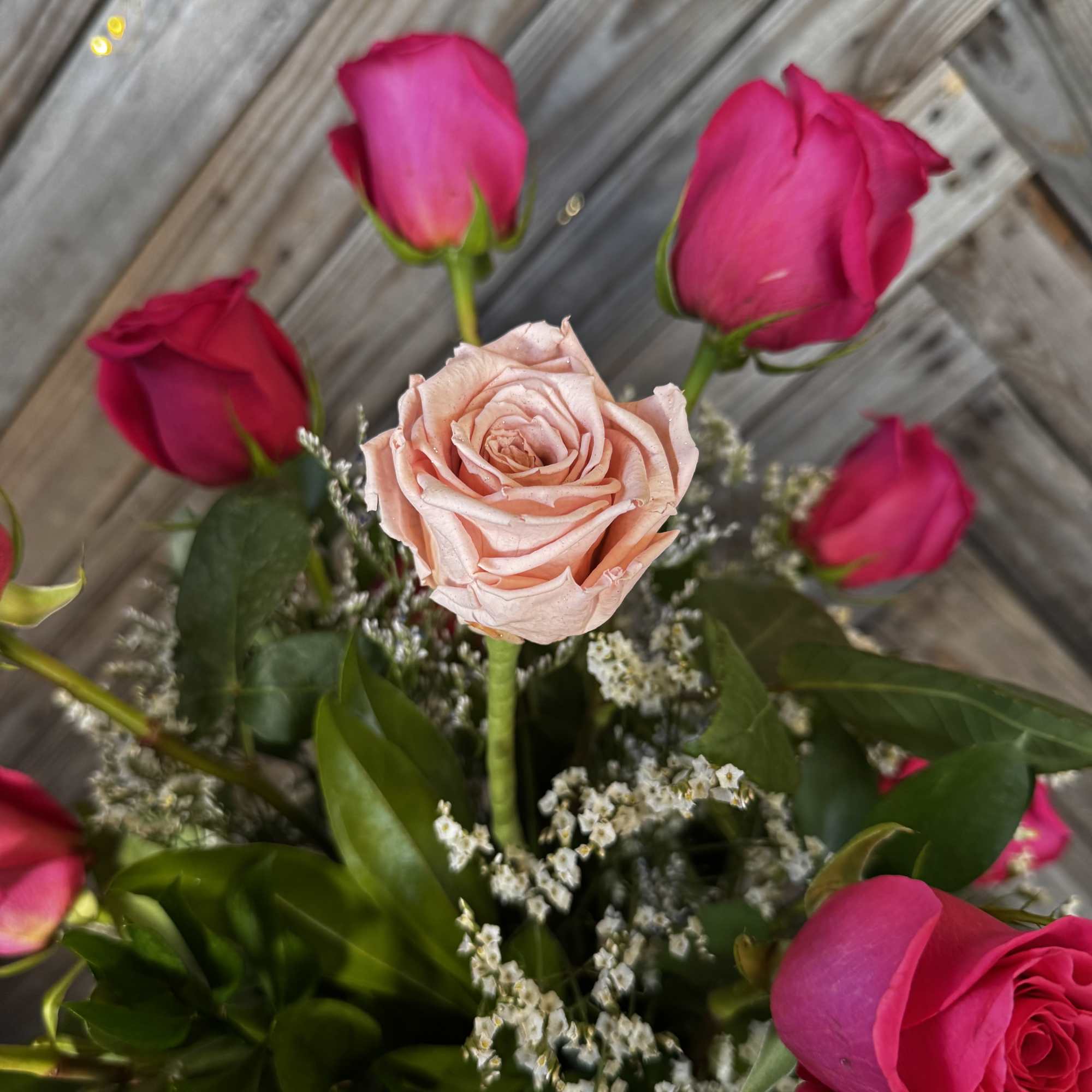 Bouquet of pink roses with a pale peach rose in the center