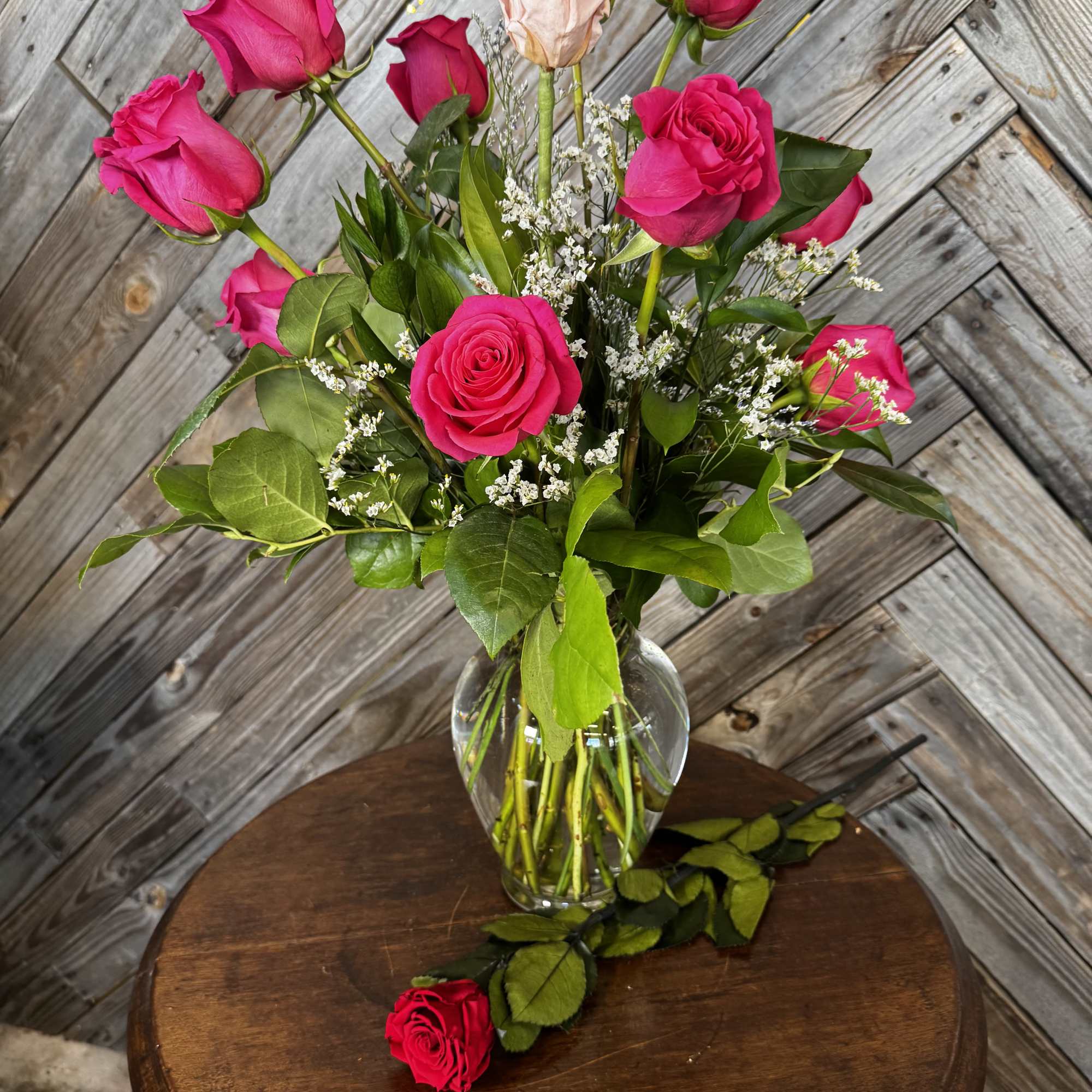Pink roses in a clear glass vase with baby's breath