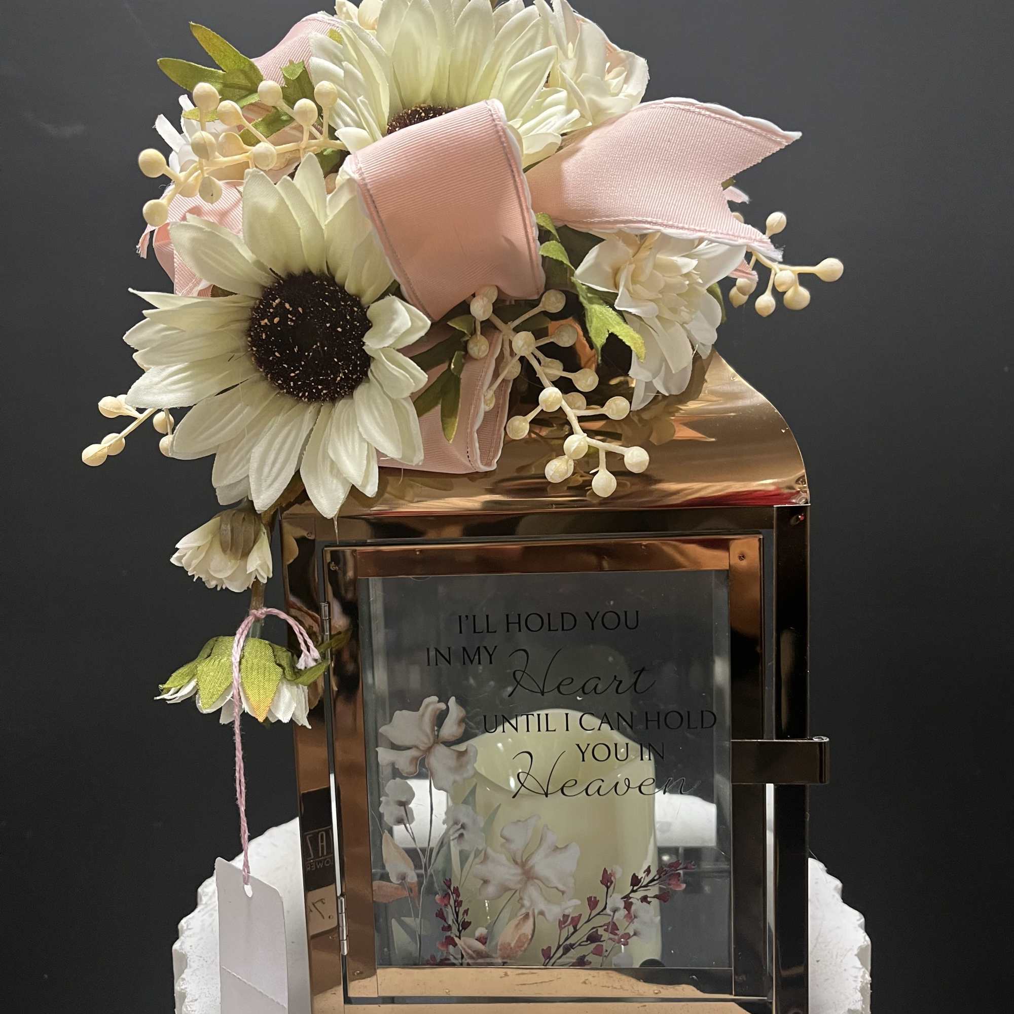 White daisy bouquet with pink ribbon on a lantern