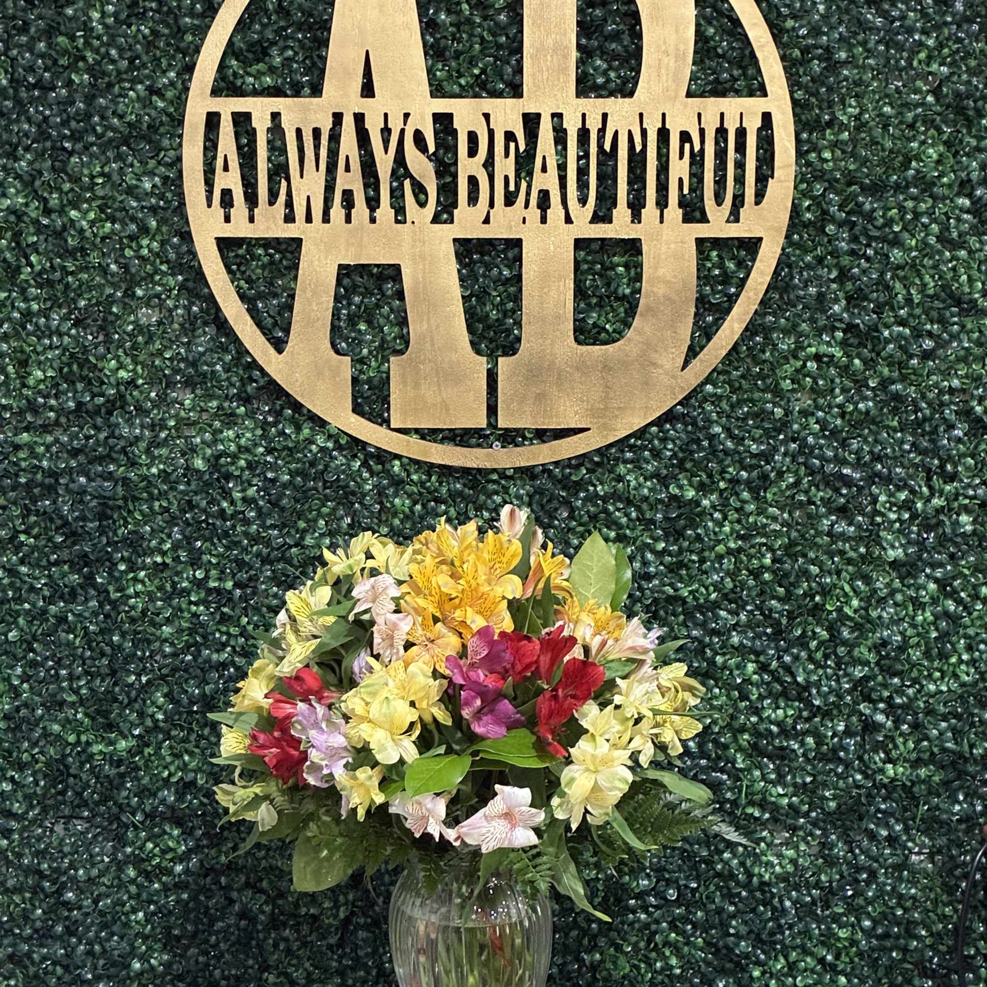 Mixed bouquet in a clear glass vase on a pedestal