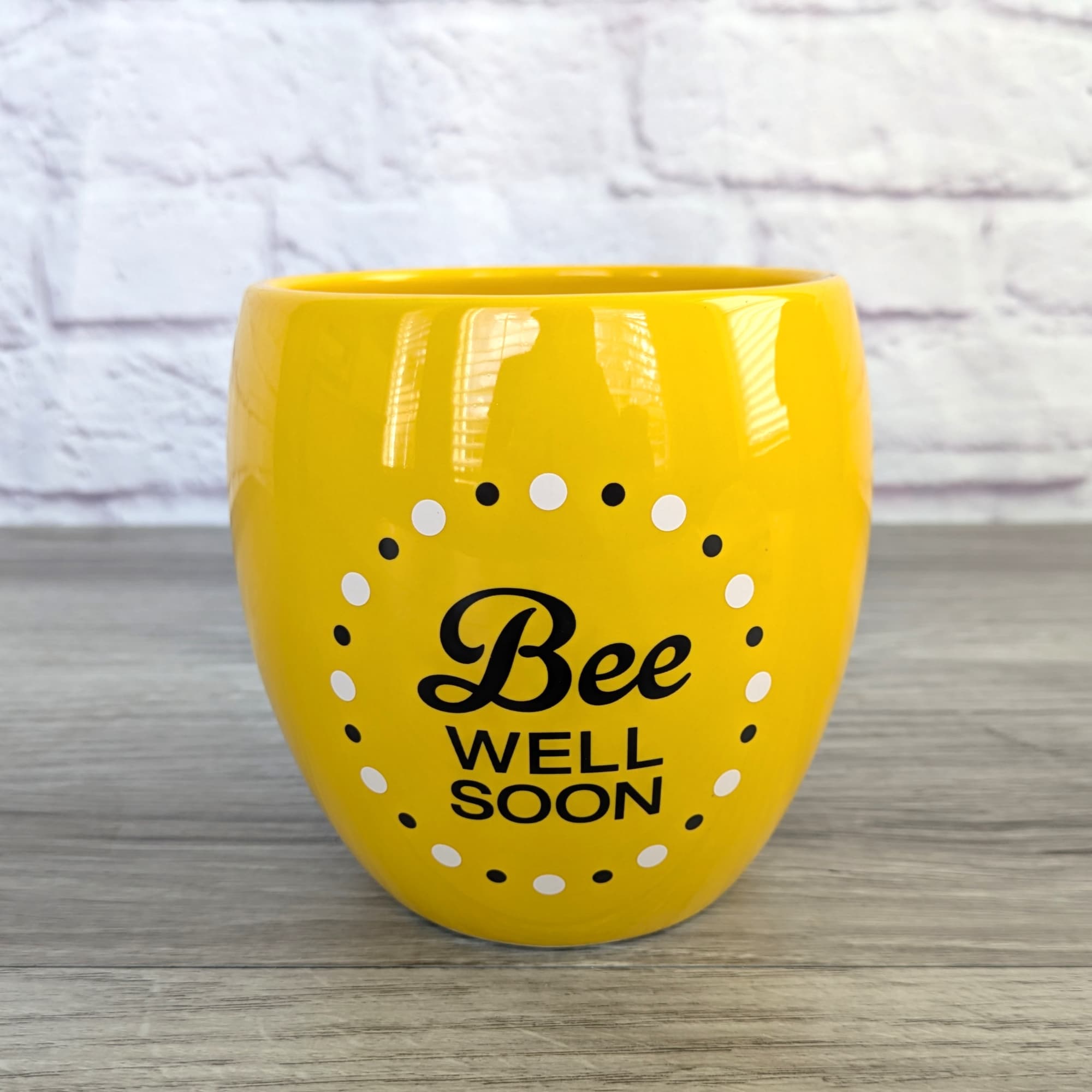 Yellow ceramic pot with "Bee Well Soon" text and dotted bee design