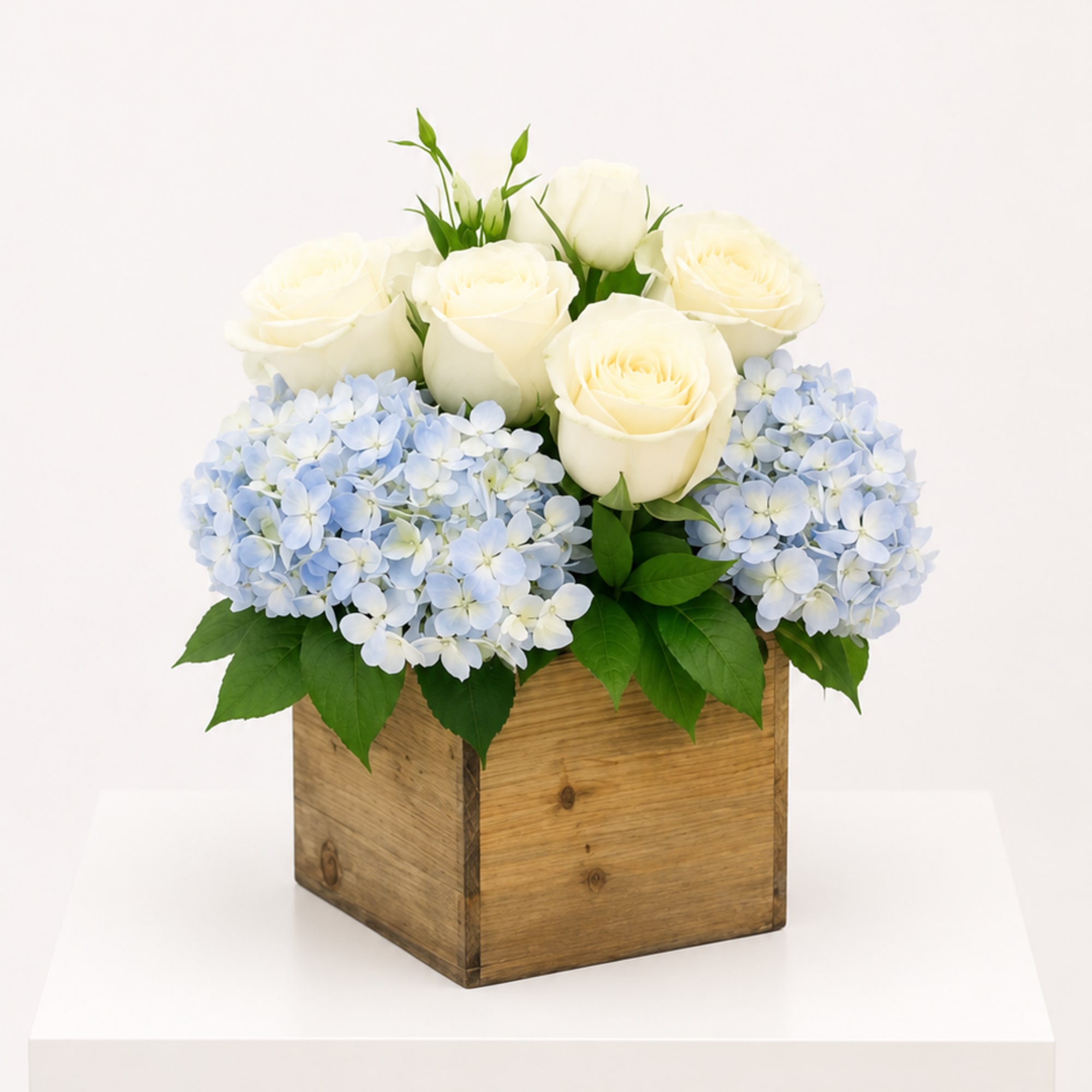 Soft blue hydrangeas paired with creamy white roses, thoughtfully designed in a