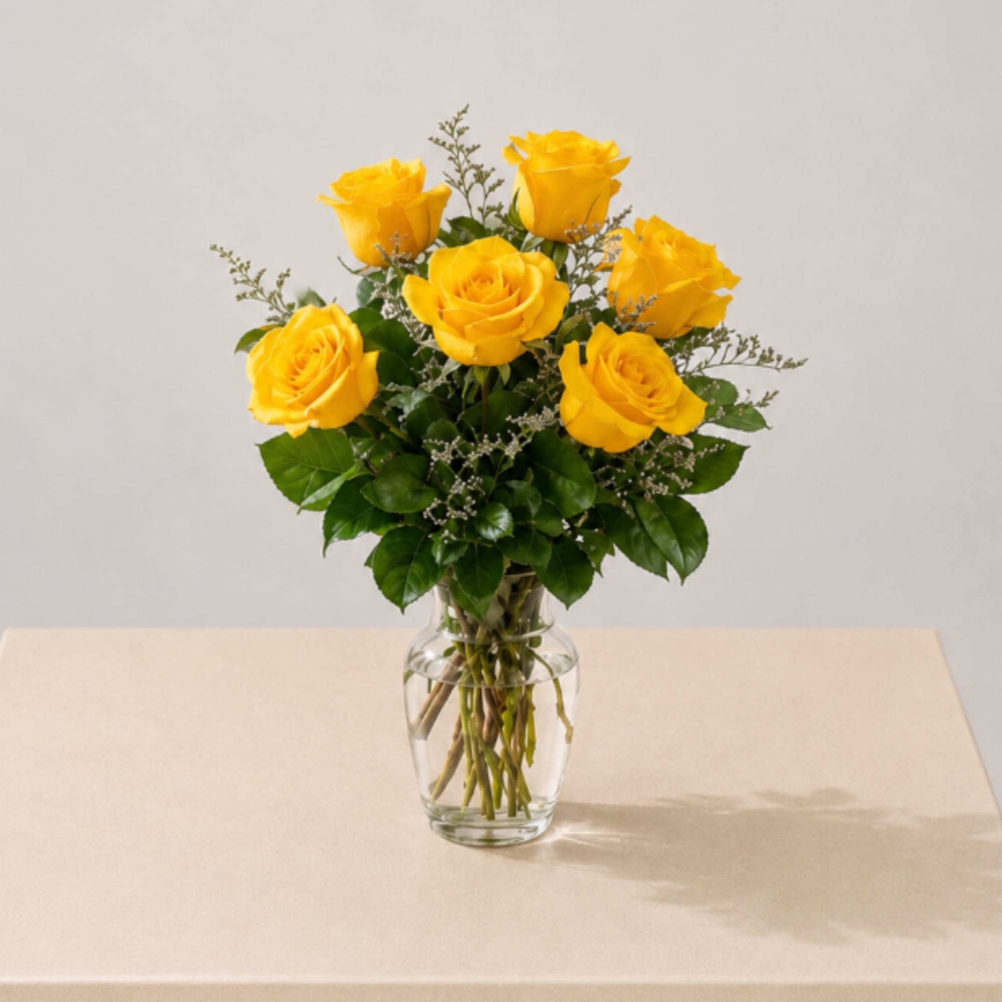 A charming vase filled with  six fresh yellow roses, designed with