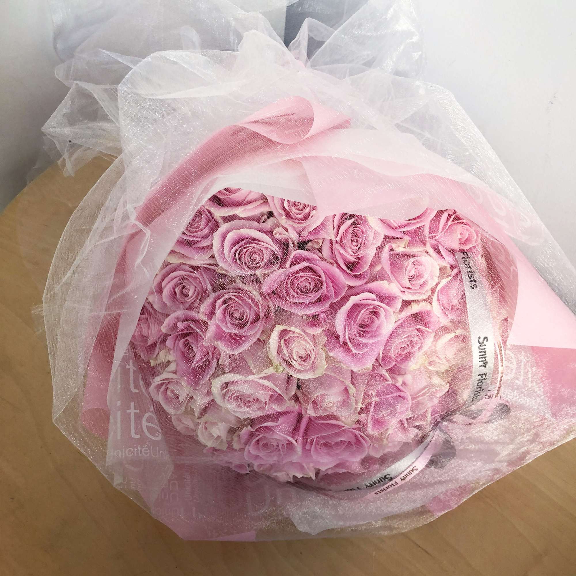 Bouquet of pink roses wrapped in sheer white mesh