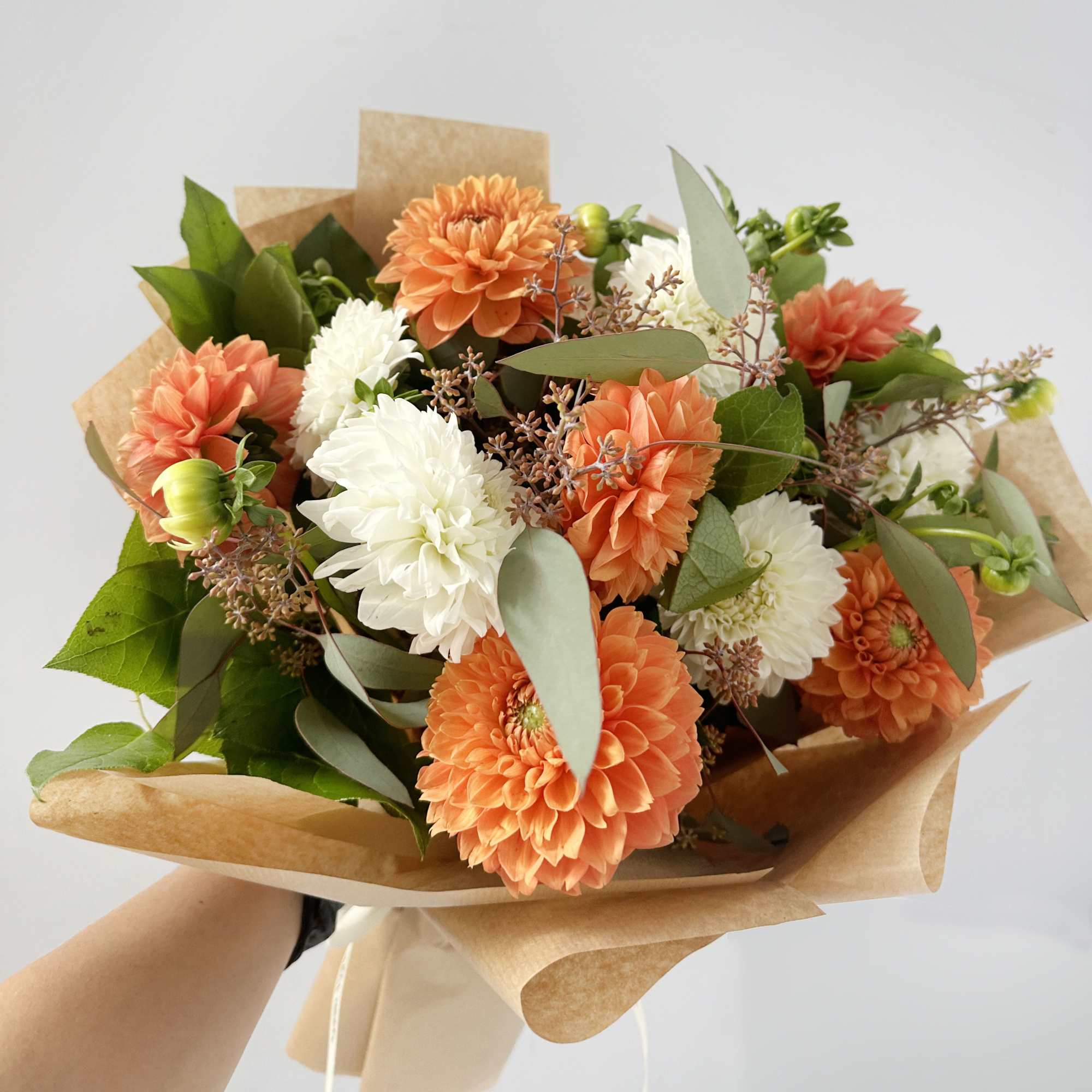 Bouquet of orange and white flowers wrapped in brown paper, photo 3 of 3
