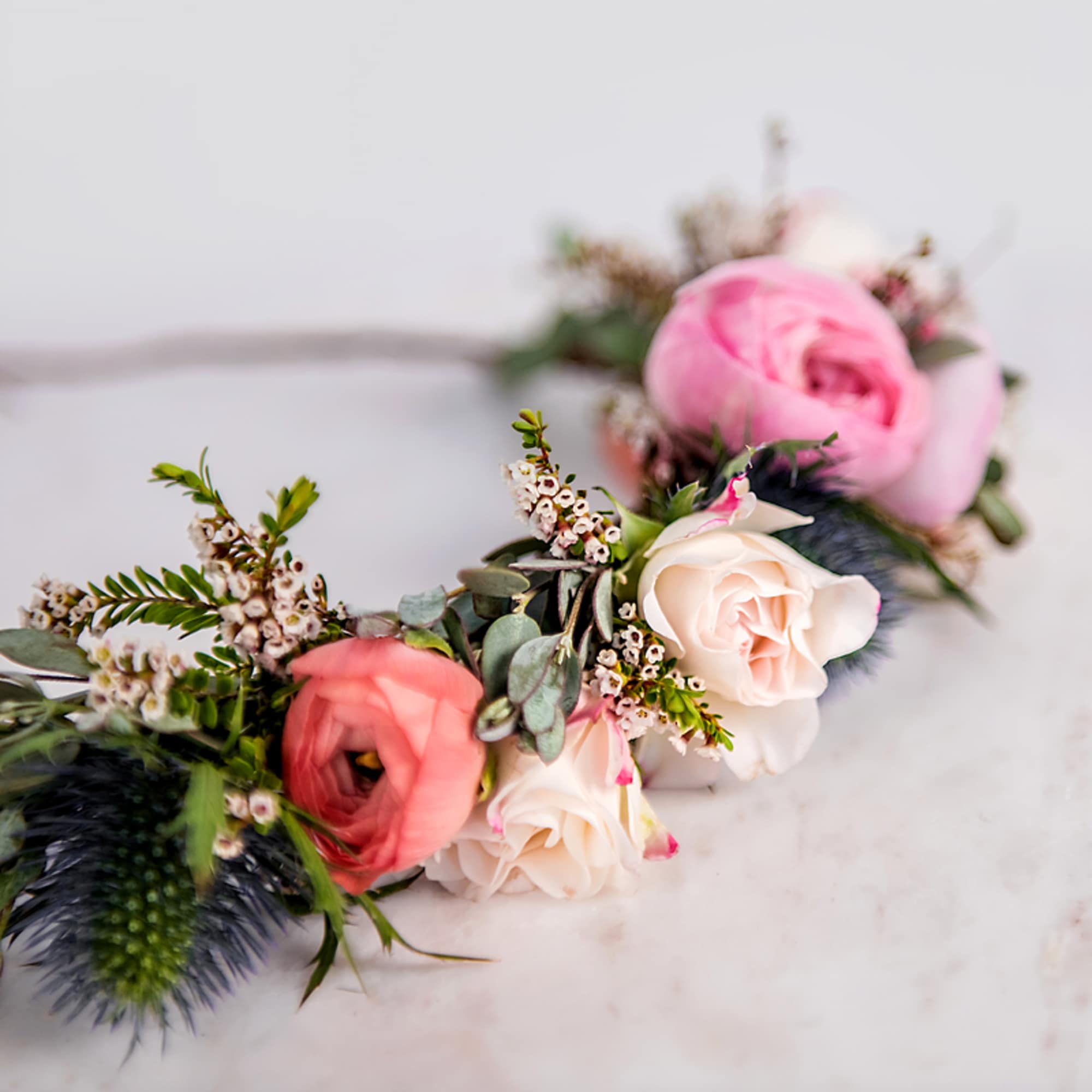 Floral crown of pink and peach blooms with white roses arranged in a circular garland