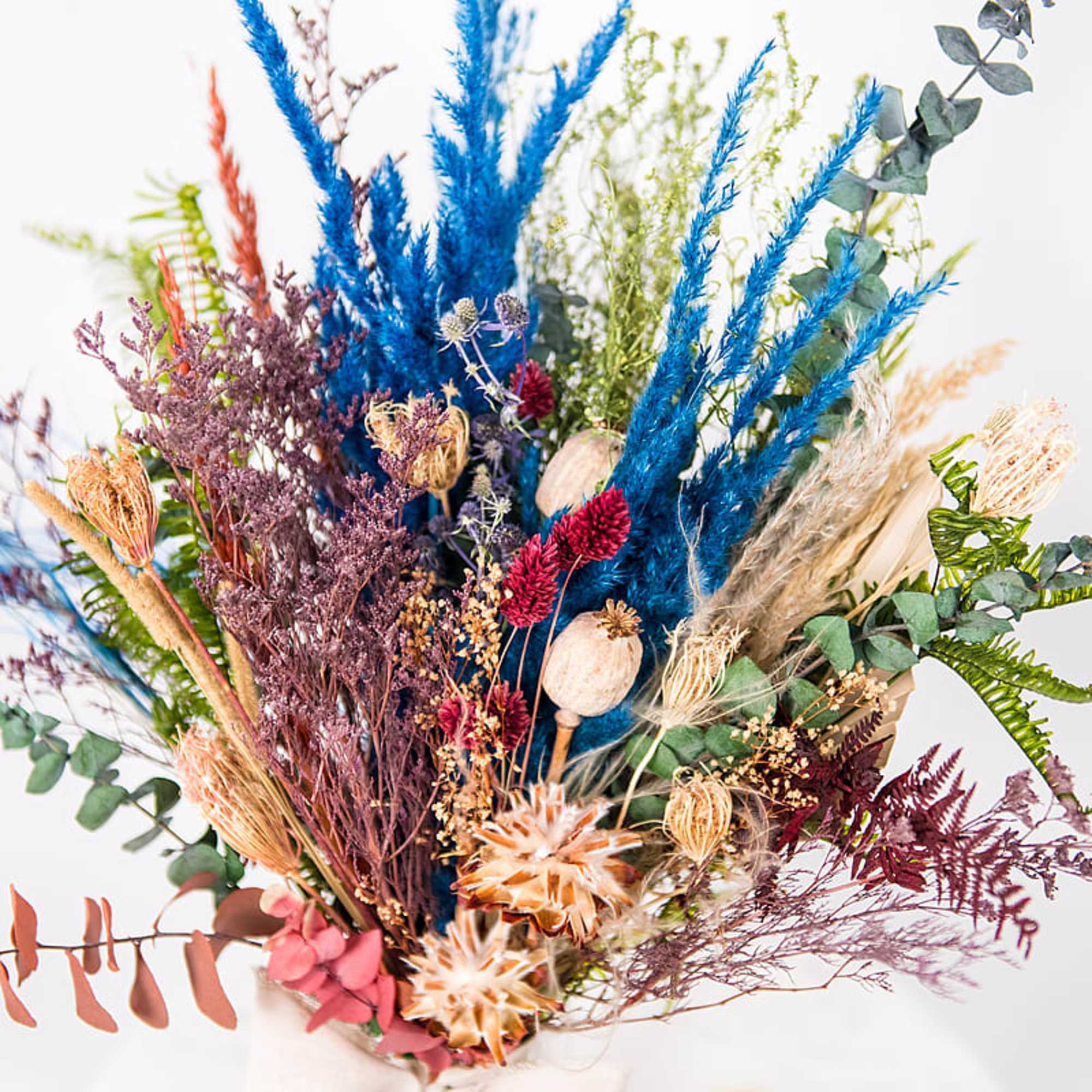 Dried bouquet with bright blue and purple grasses and eucalyptus