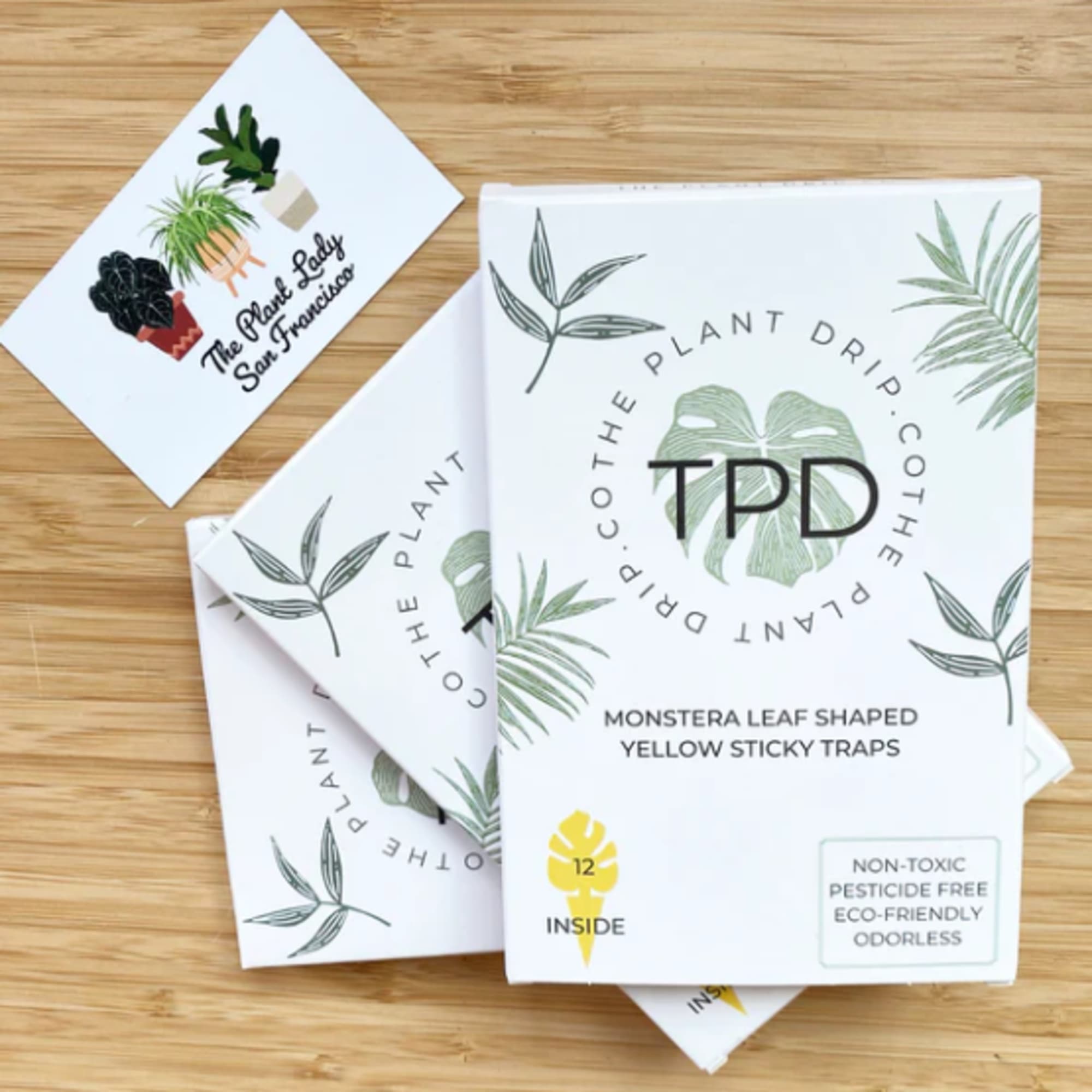 Plant-themed sticky trap packages on a wooden surface