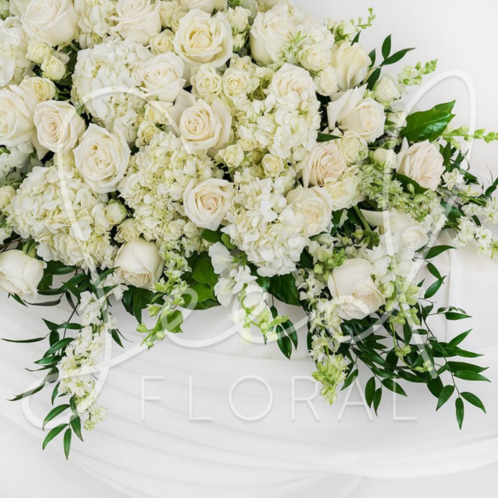 White rose and hydrangea arrangement with trailing greenery