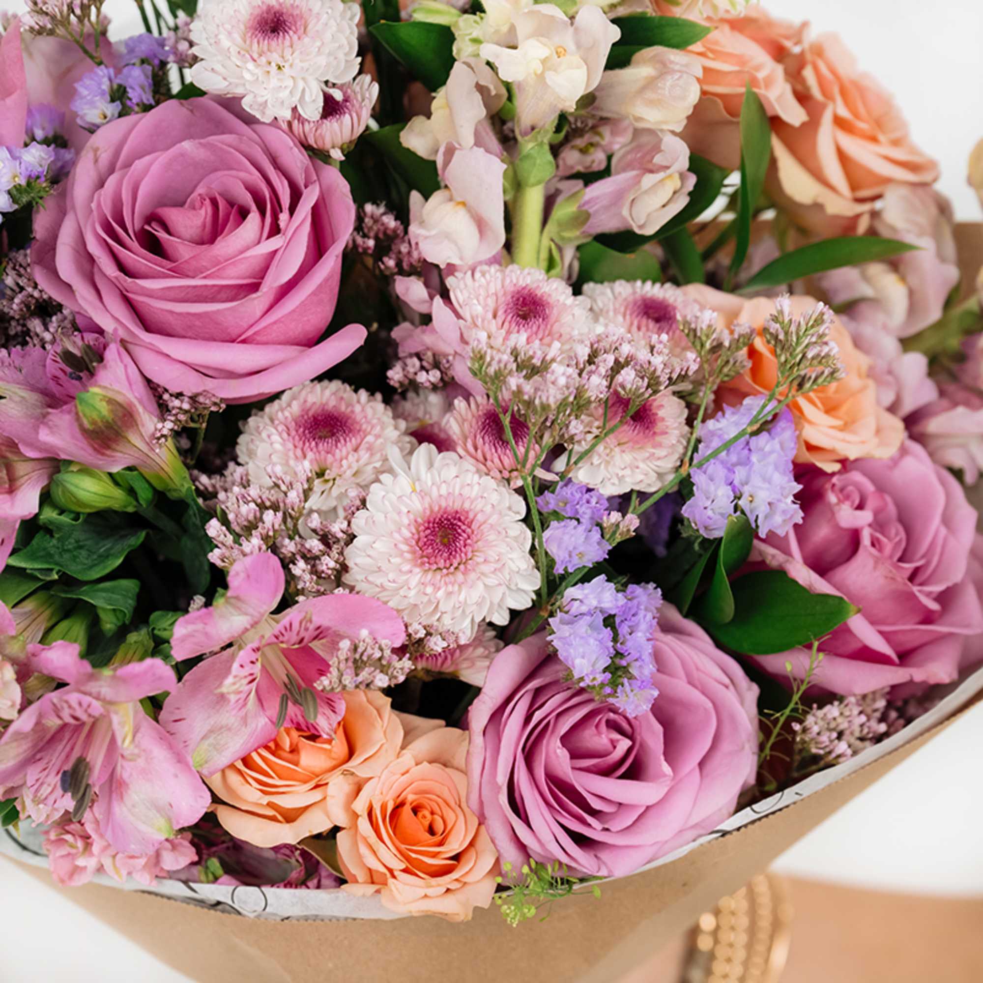 Bouquet of pink and peach roses with mixed pastel flowers