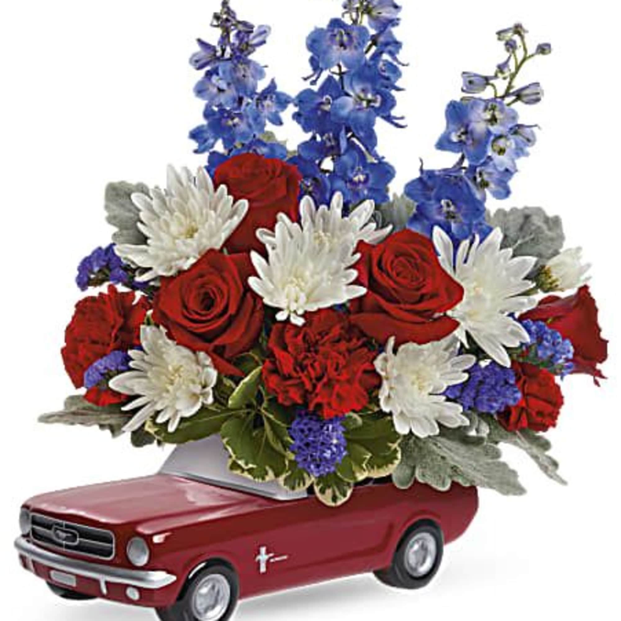 Red and white flowers arranged in a red toy car container