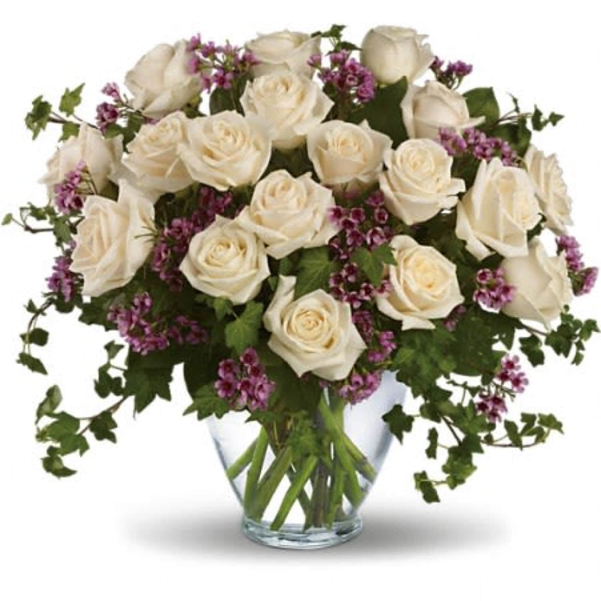 Cream roses and purple filler flowers in a clear glass vase