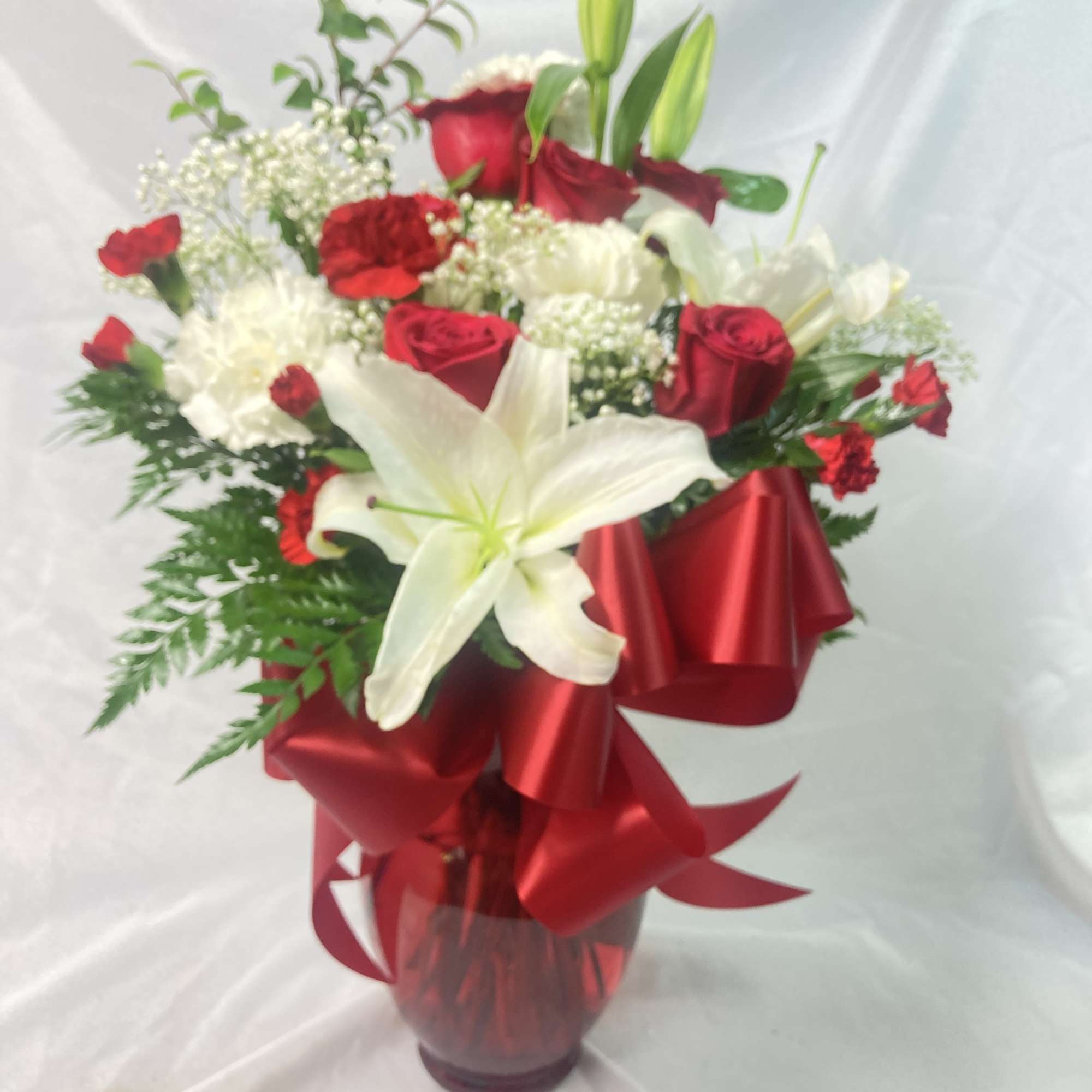 Red and white flower arrangement in a glass vase with a red ribbon, photo 2 of 2