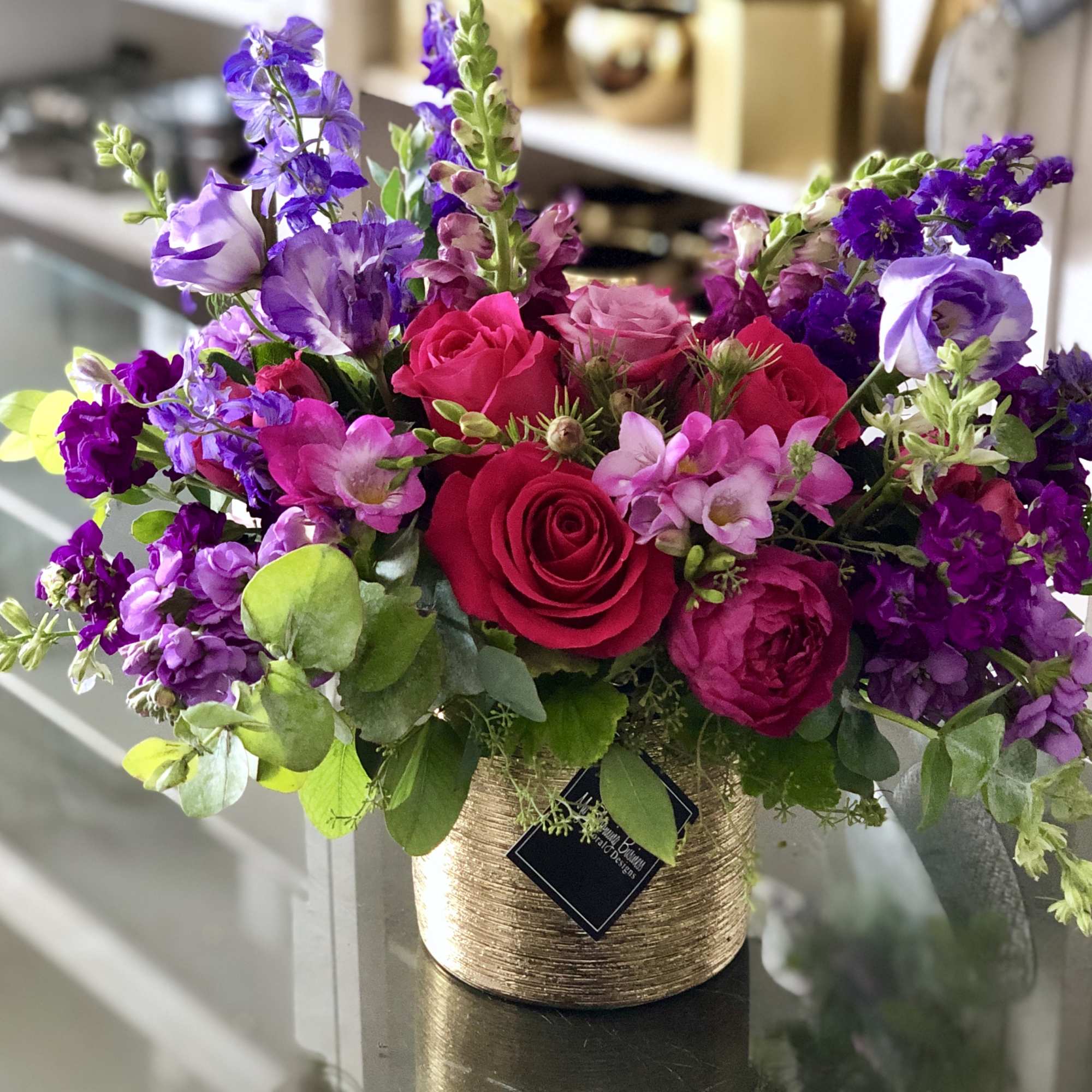 Bouquet of pink and purple flowers in a gold textured vase