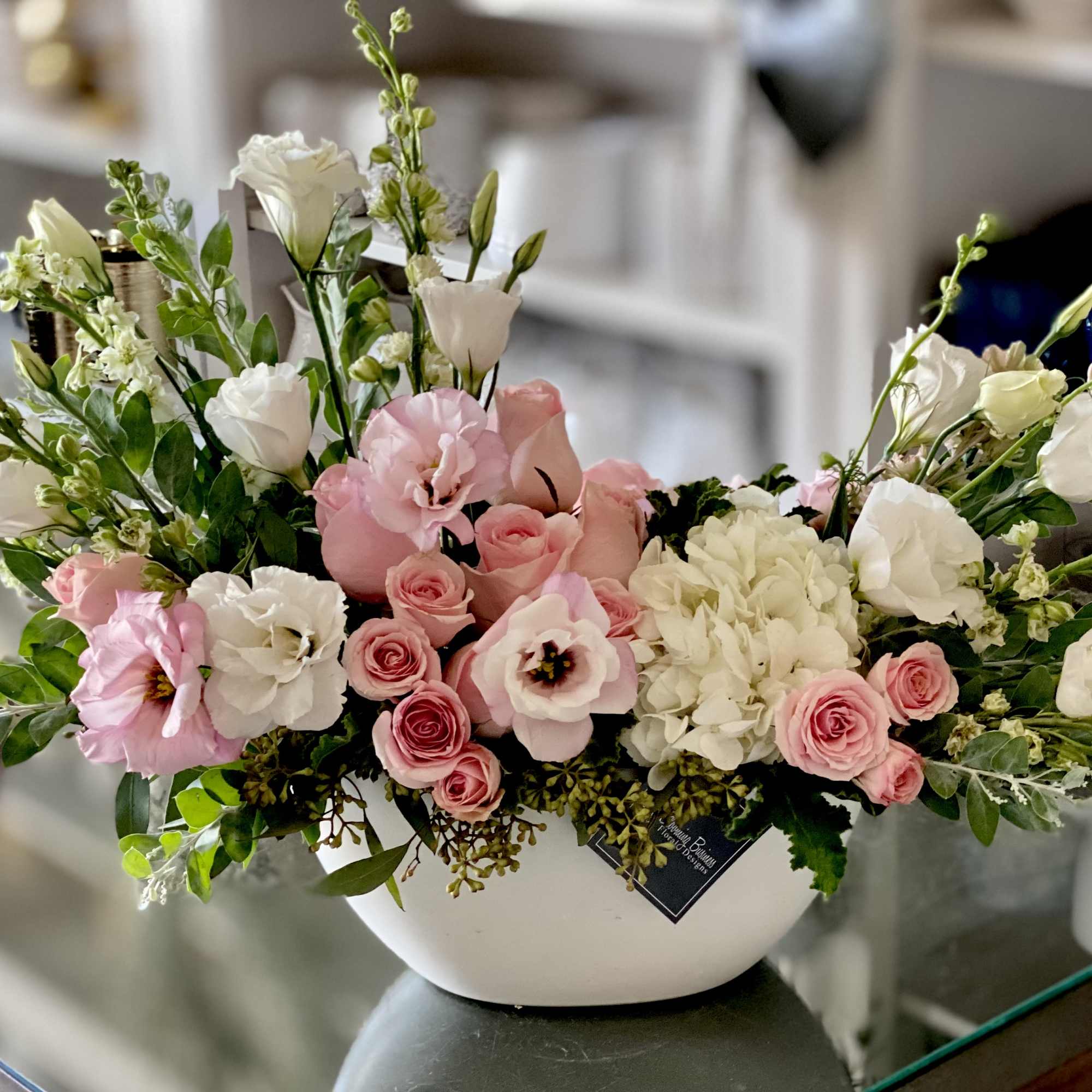 The Savannah Arrangement is filed with light pink roses, spray roses, lisianthus