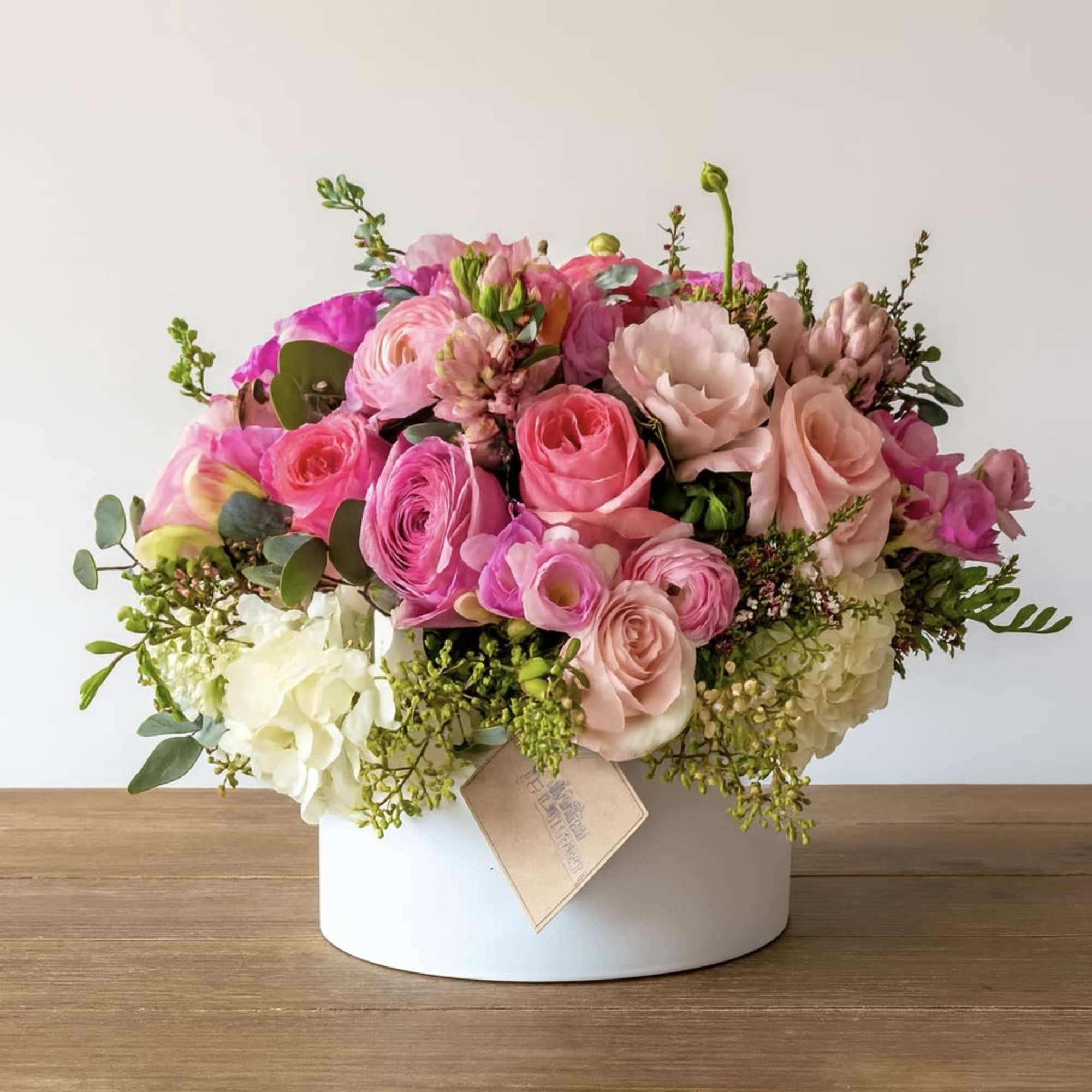 Pink and white mixed flower arrangement in a white box
