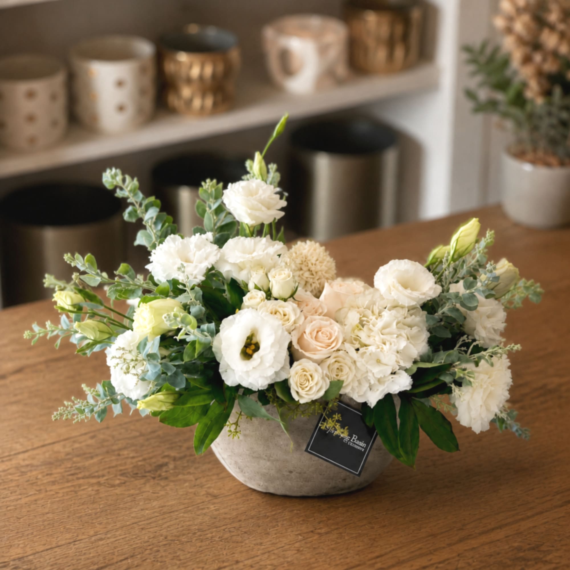 White and cream floral arrangement in a low ceramic bowl