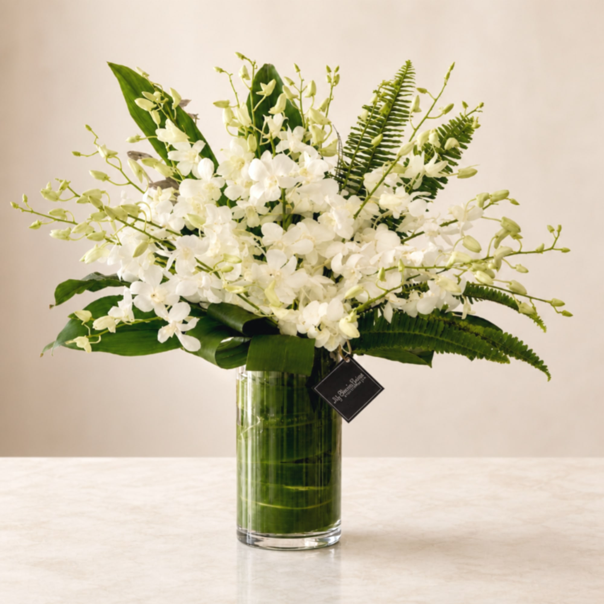 White orchid arrangement in a tall glass vase, photo 2 of 2
