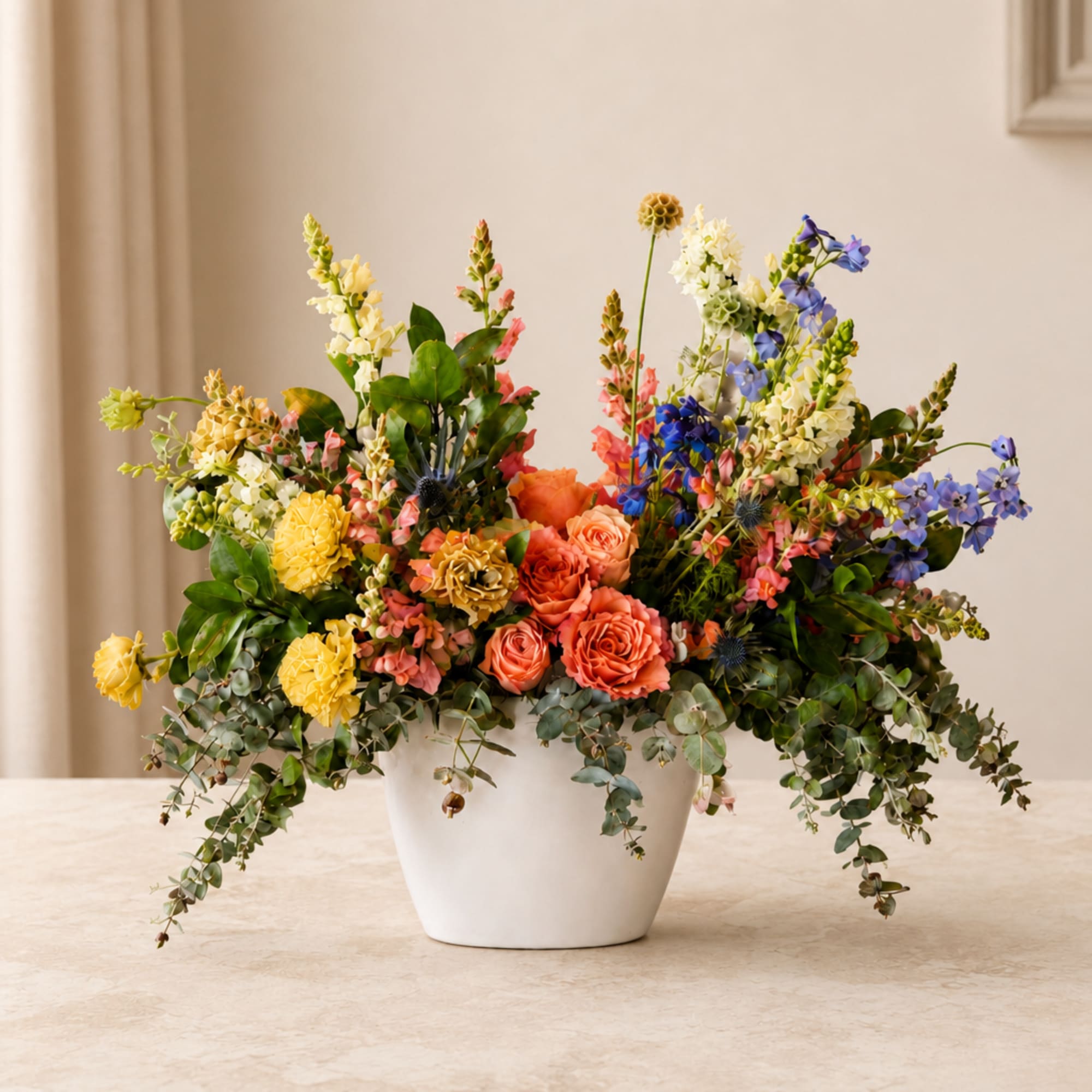 Colorful mixed flower arrangement in a white pot
