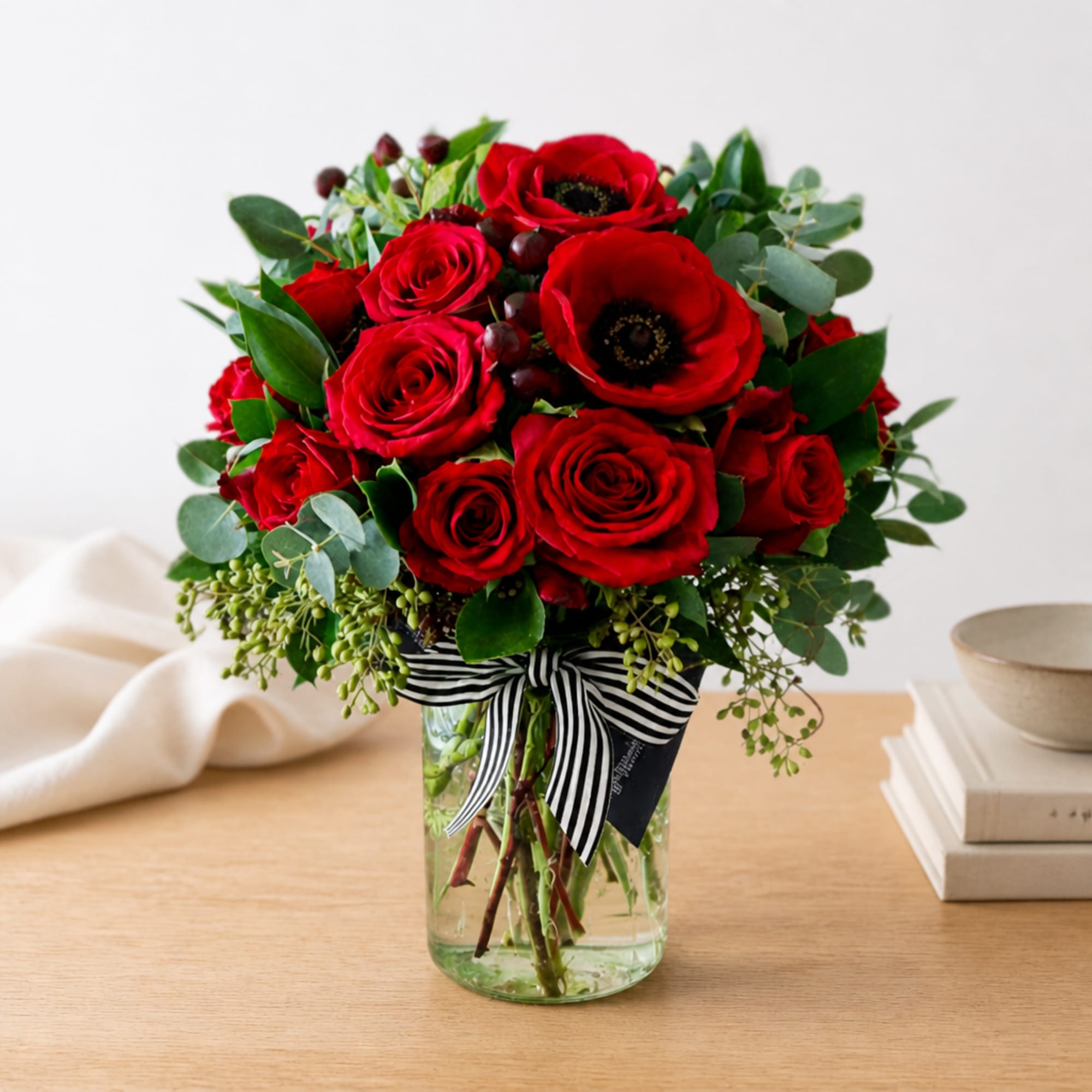 Red roses and anemones in a glass vase with a striped ribbon, photo 2 of 2