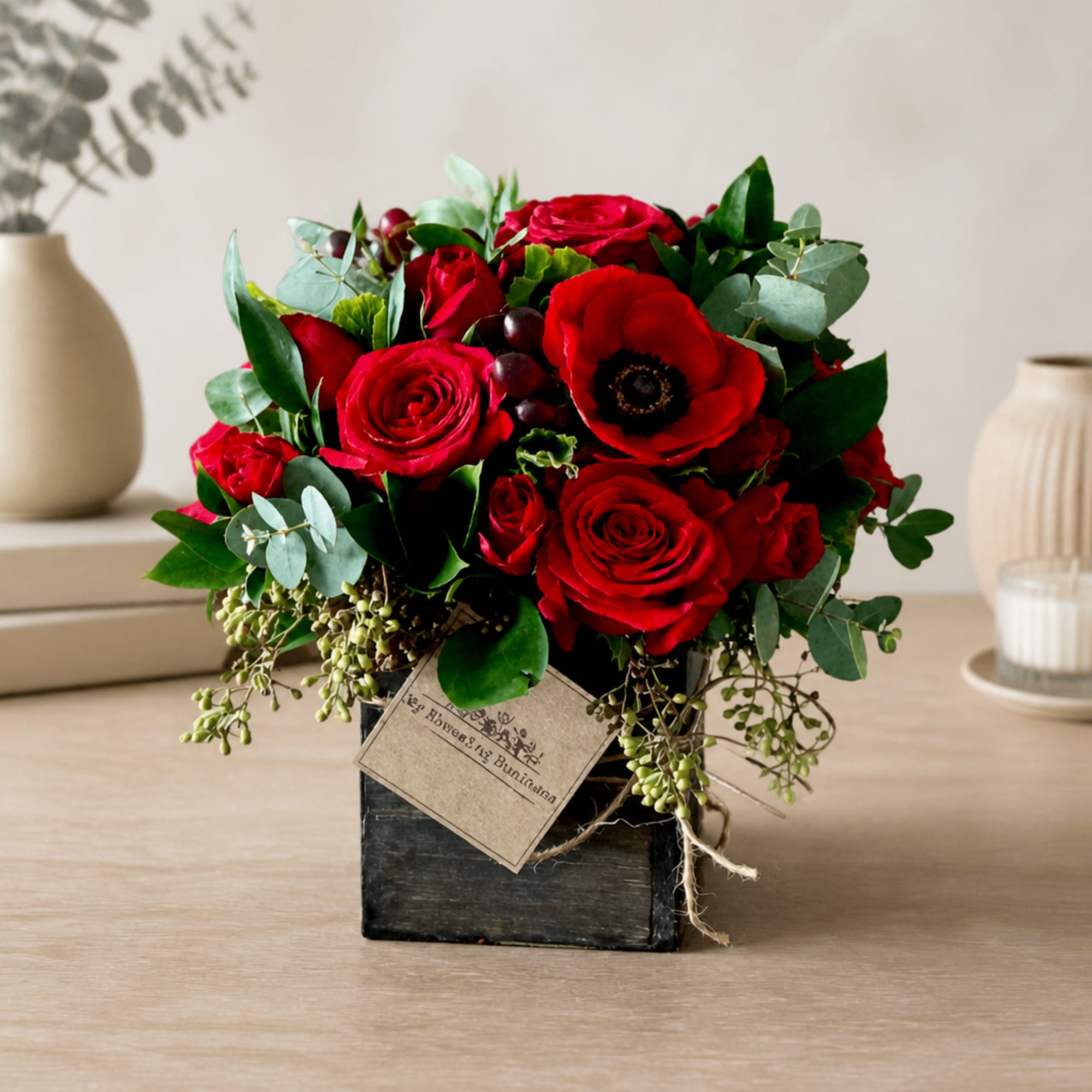 Red rose and anemone arrangement in a black wooden box