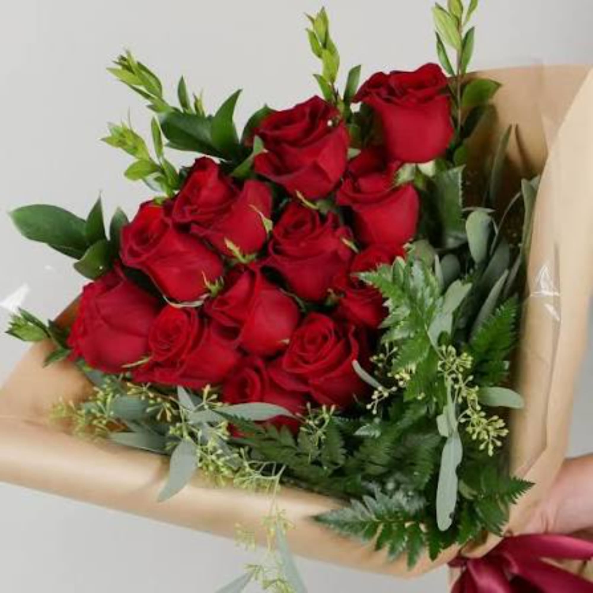 Bouquet of red roses wrapped in tan paper