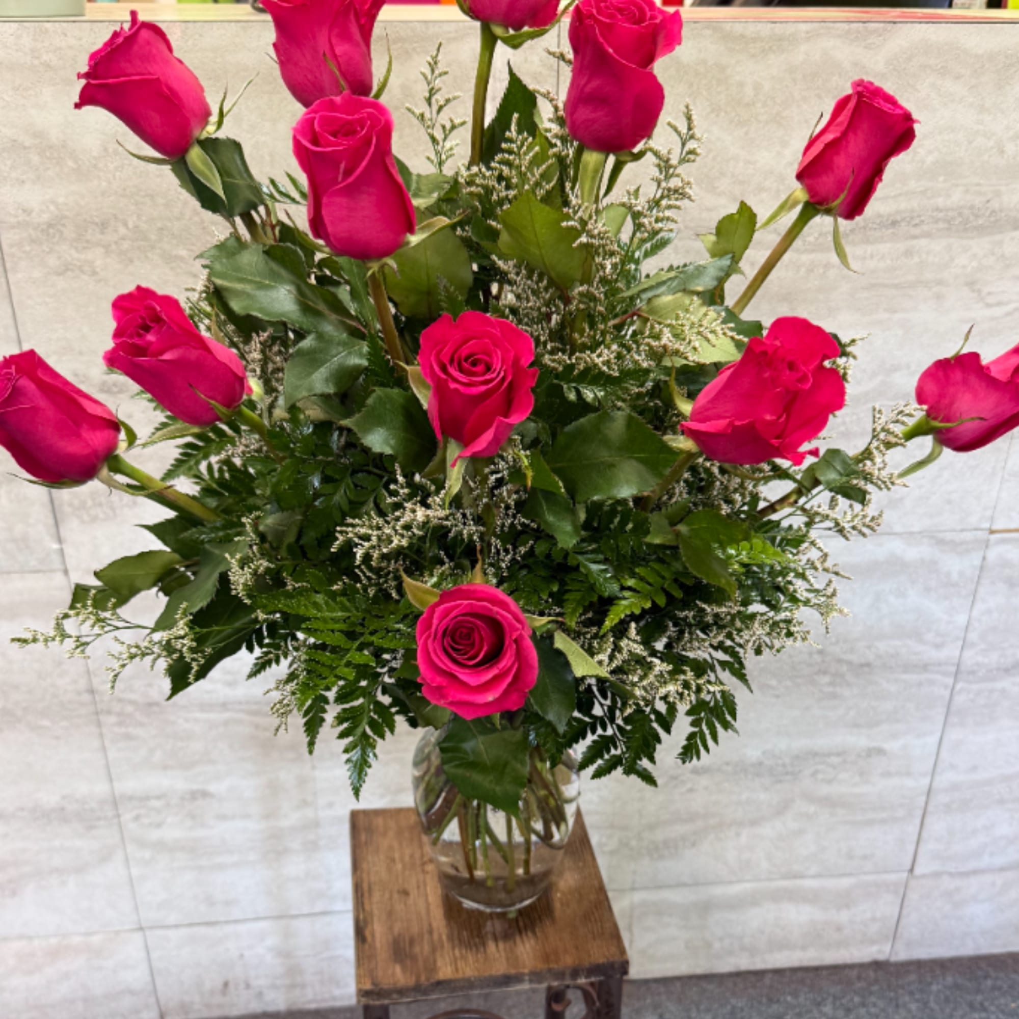 Tall bouquet of hot pink roses in a clear glass vase