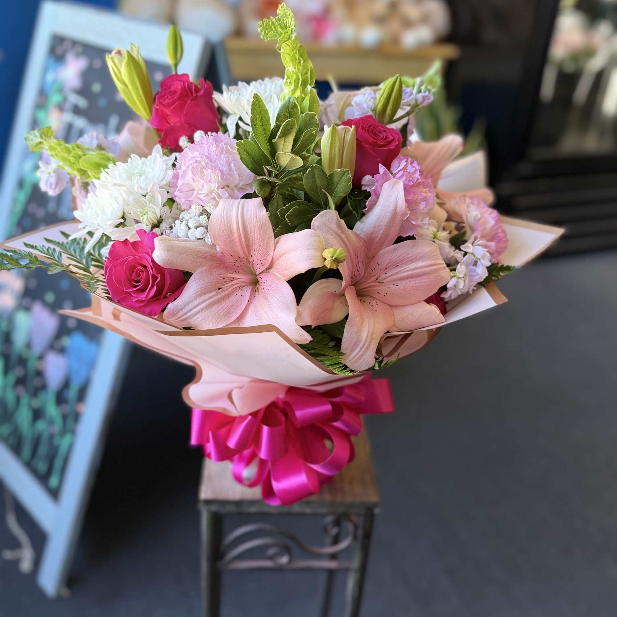 Pink and white lilies, hot-pink roses, chrysanthemums and carnations with green accents