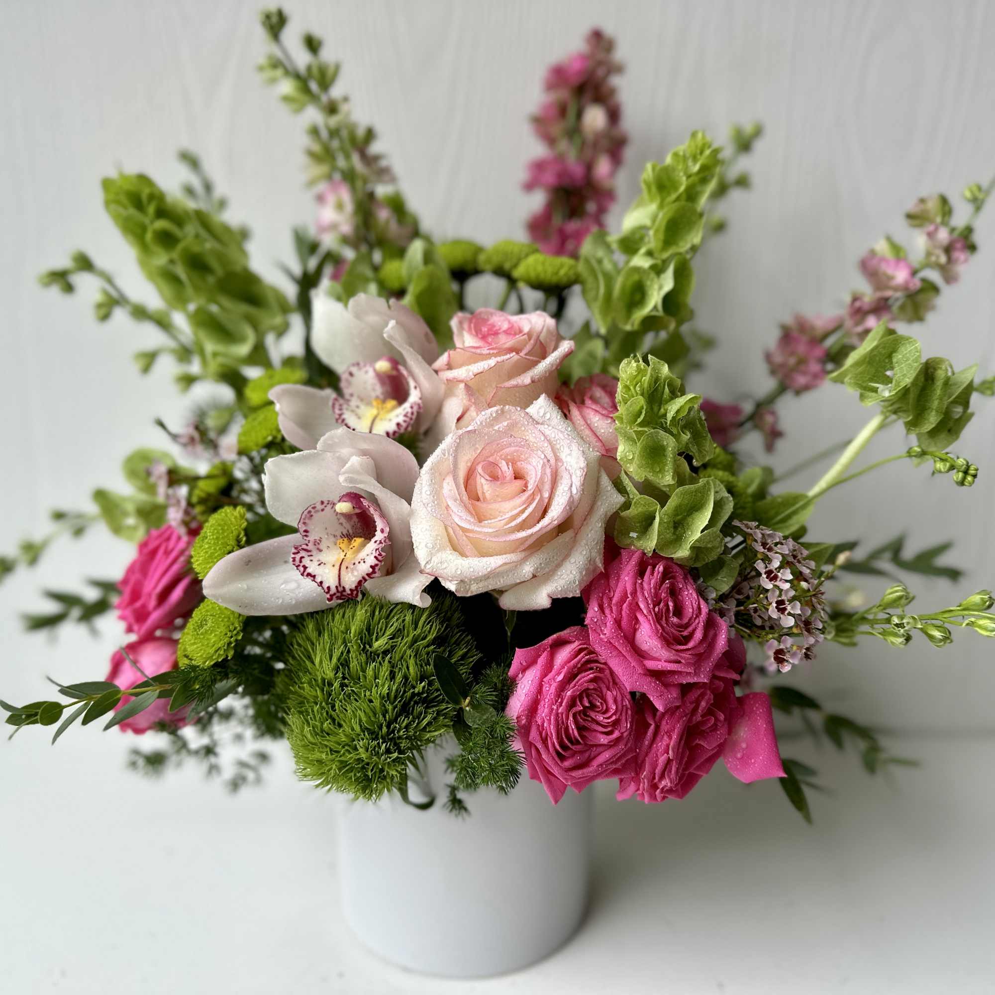 A cheerful blend of pinks and fresh greens, this flower arrangement is