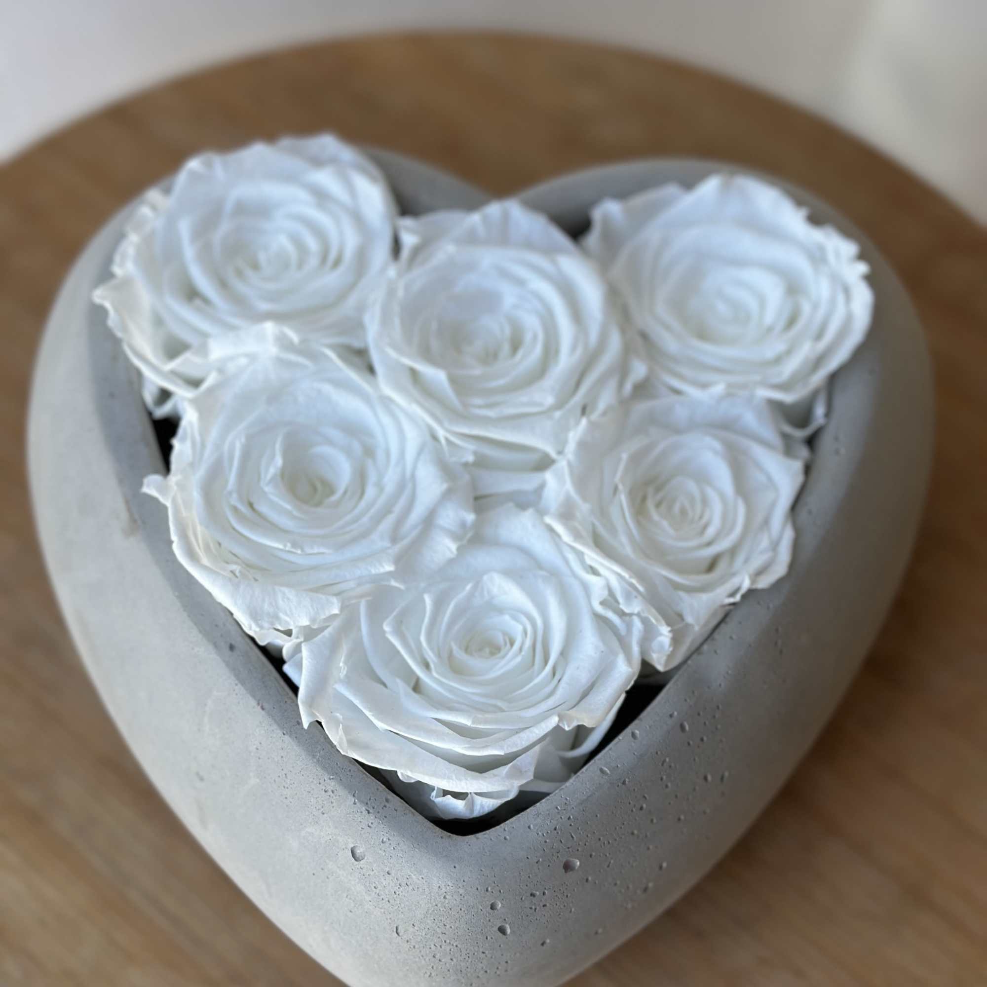 Heart-shaped box filled with white roses