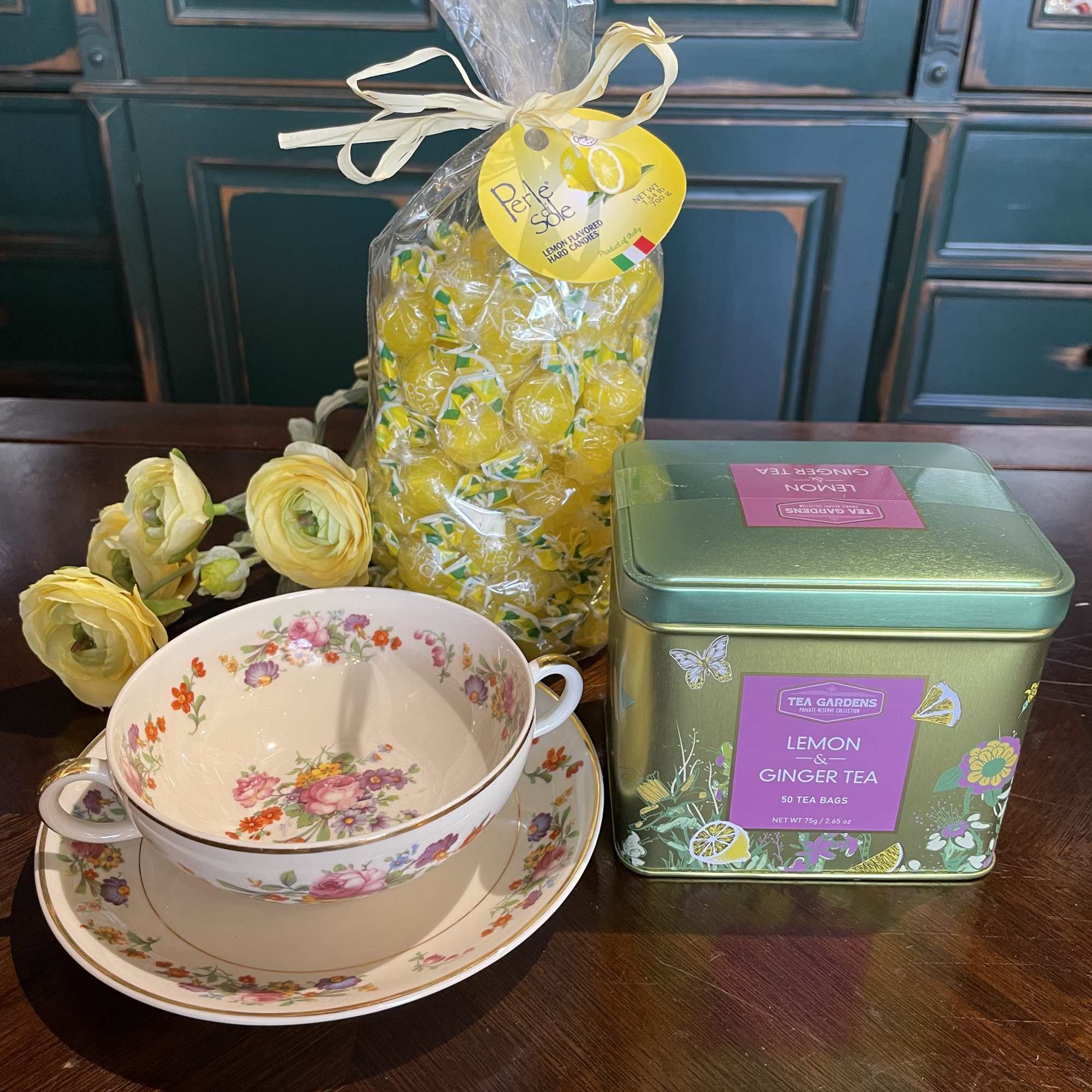 Floral teacup set with lemon candies and tea tins
