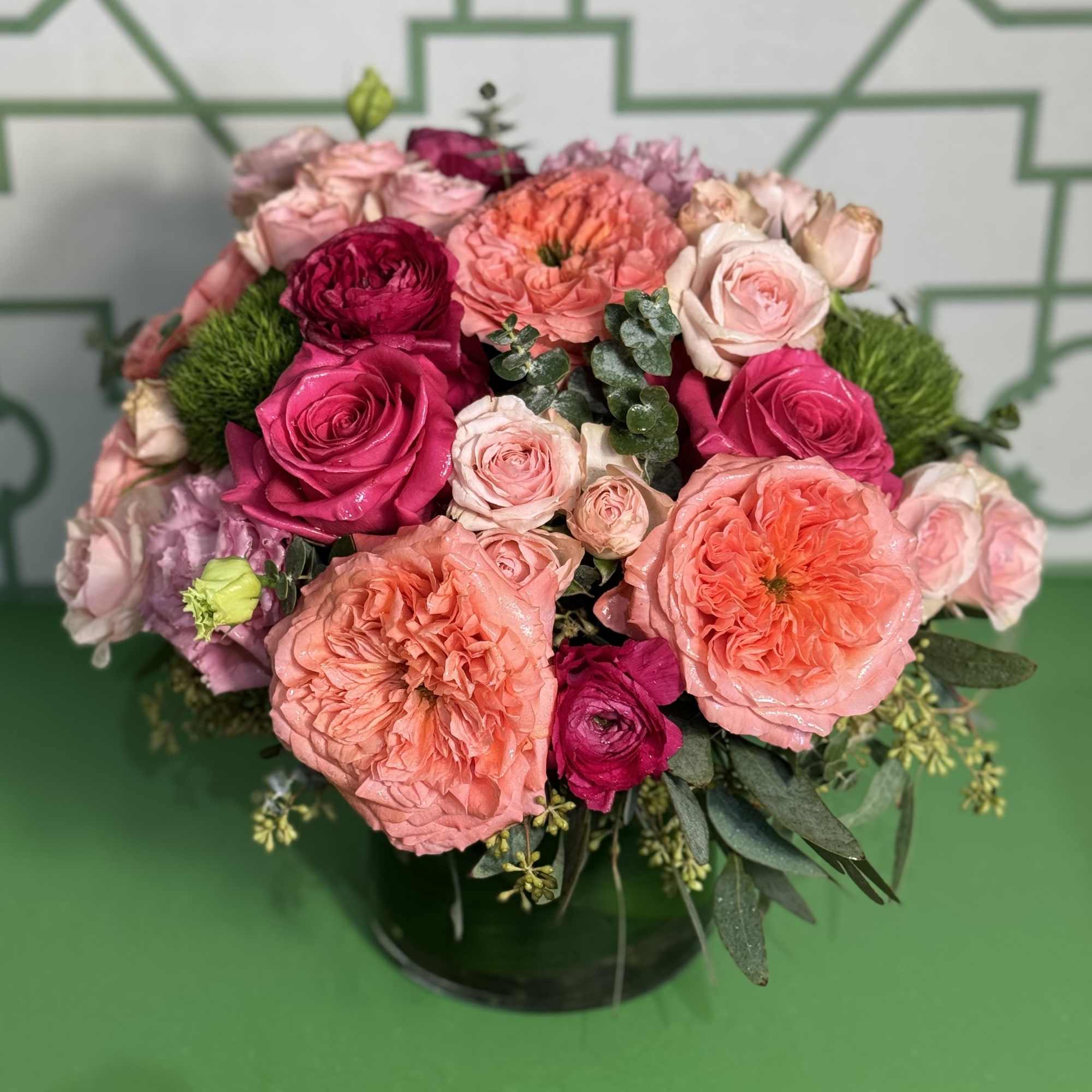 Pink and peach roses arranged in a black vase