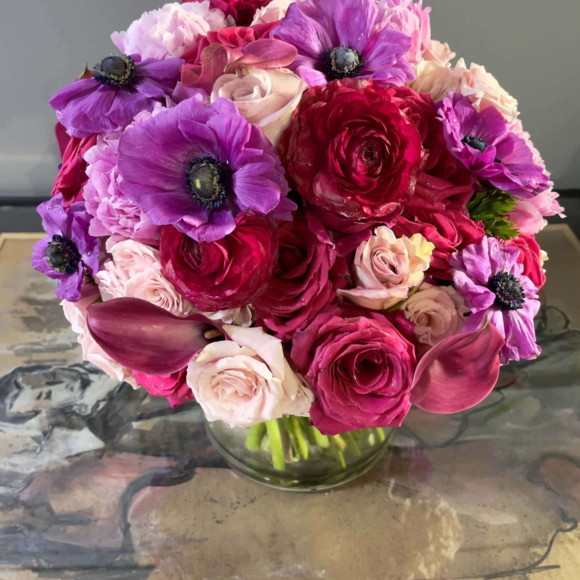 Bouquet of pink and purple flowers in a clear glass vase
