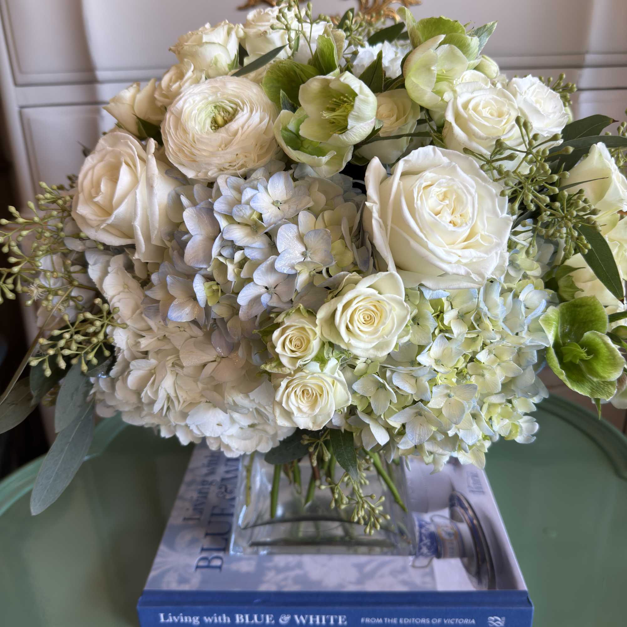 White roses and pale hydrangeas in a glass vase