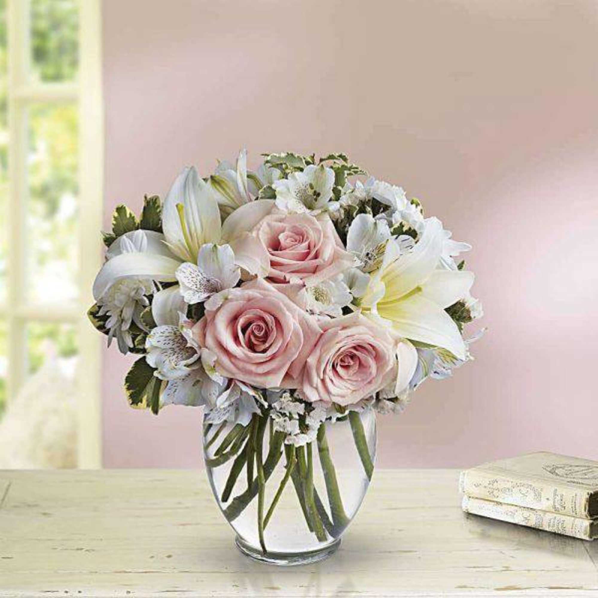Pink roses and white lilies arranged in a clear glass vase, photo 2 of 2