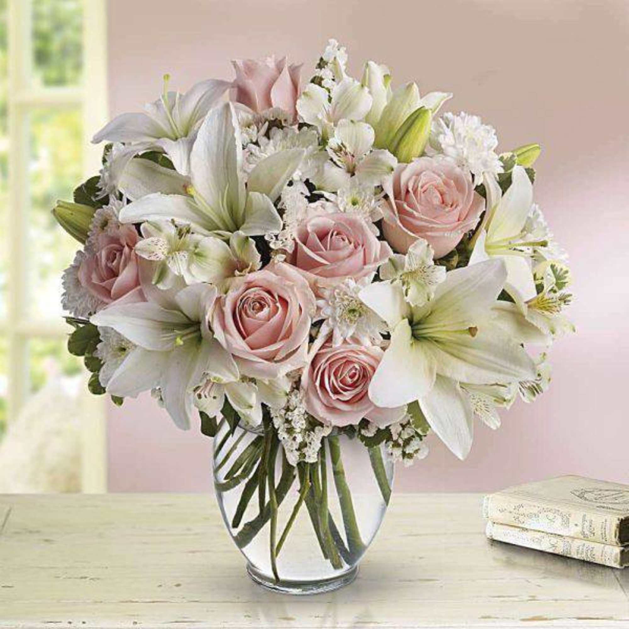 Pink roses and white lilies arranged in a clear glass vase, photo 2 of 2