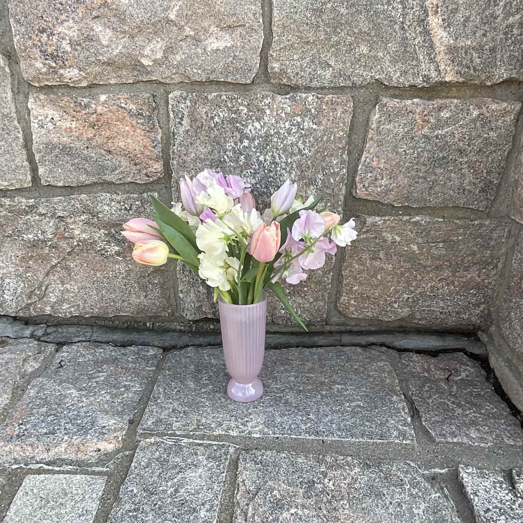 Pastel bouquet of tulips and stock in a lavender vase