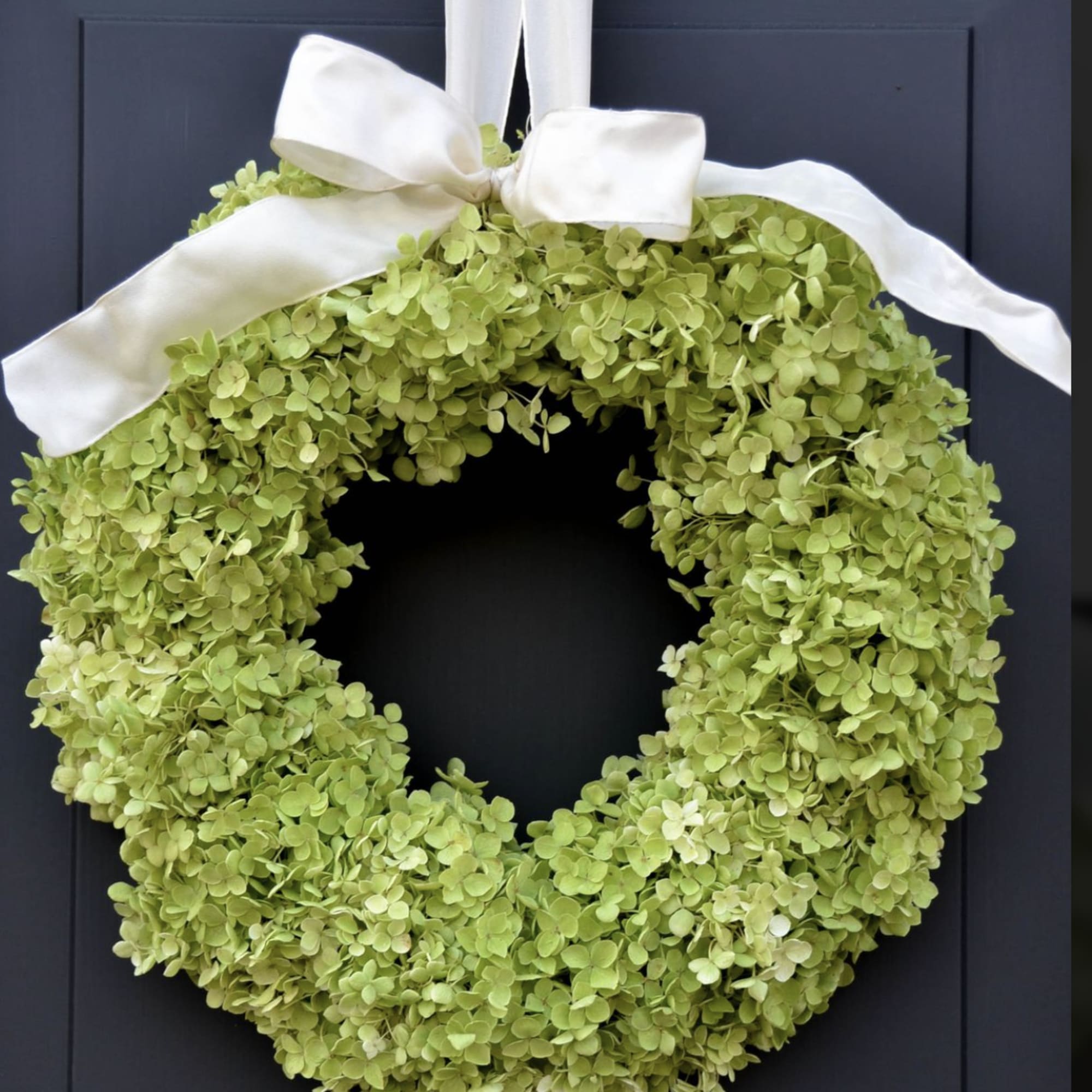 Green hydrangea wreath with a white ribbon bow